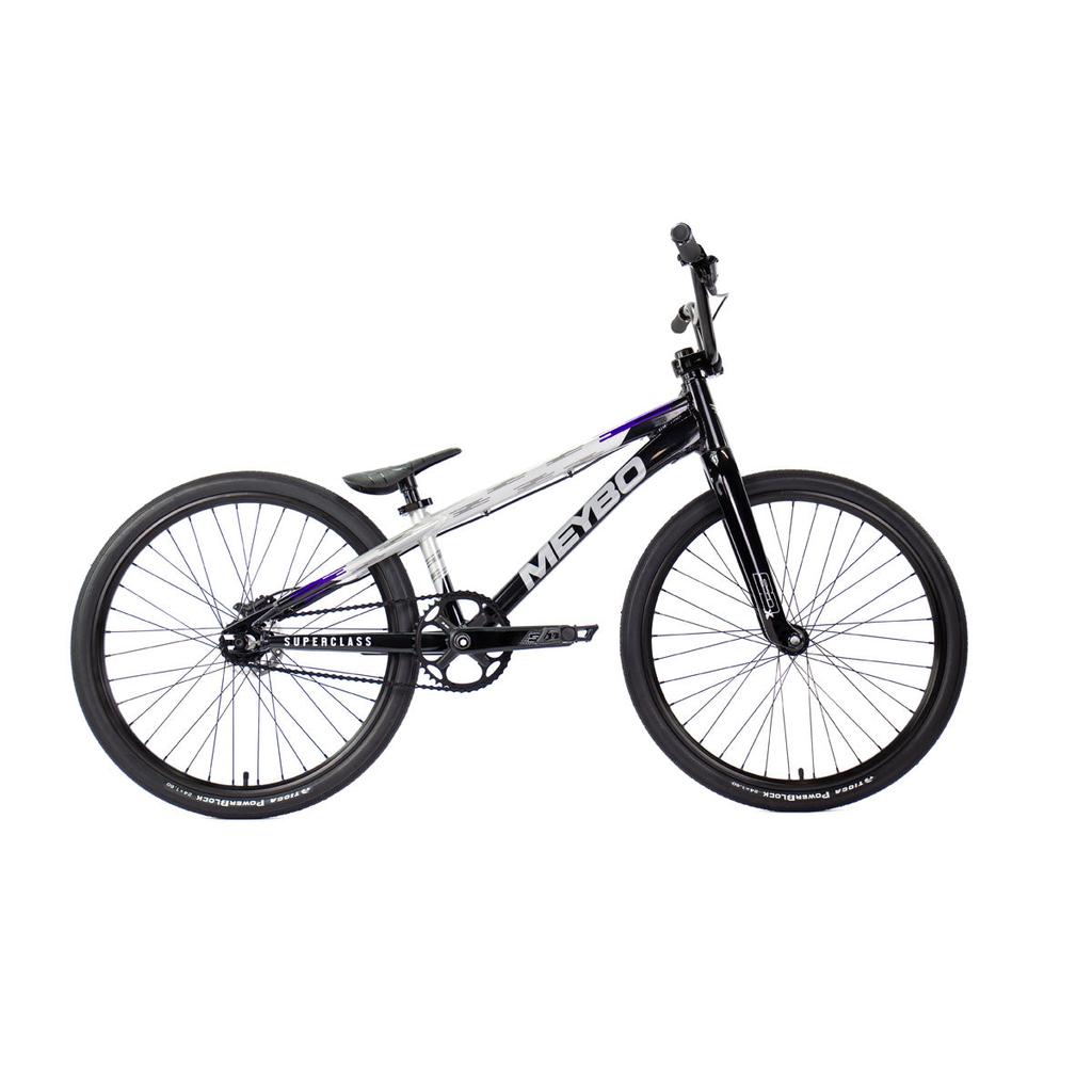 The Meybo 2026 Superclass Pro Cruiser Bike, shown in profile on a white background, is a black and white BMX racing bike with a lightweight frame, thin tires, high handlebars, and a 22-inch top tube for tall riders' comfort and control.