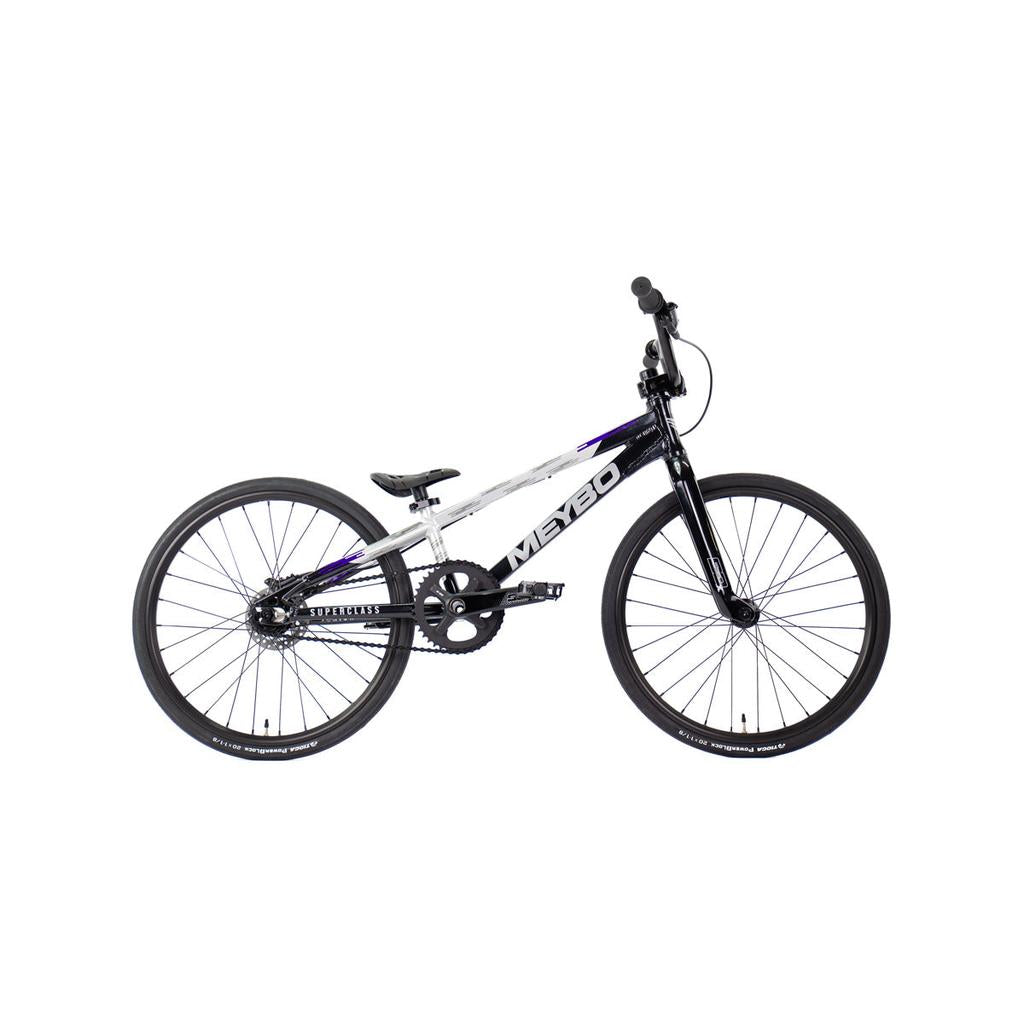 The Meybo 2026 Superclass Junior Bike is a black and white BMX racing bike with a lightweight frame, 22” top tube, flat pedals, and thin tires, shown in side view on a white background.