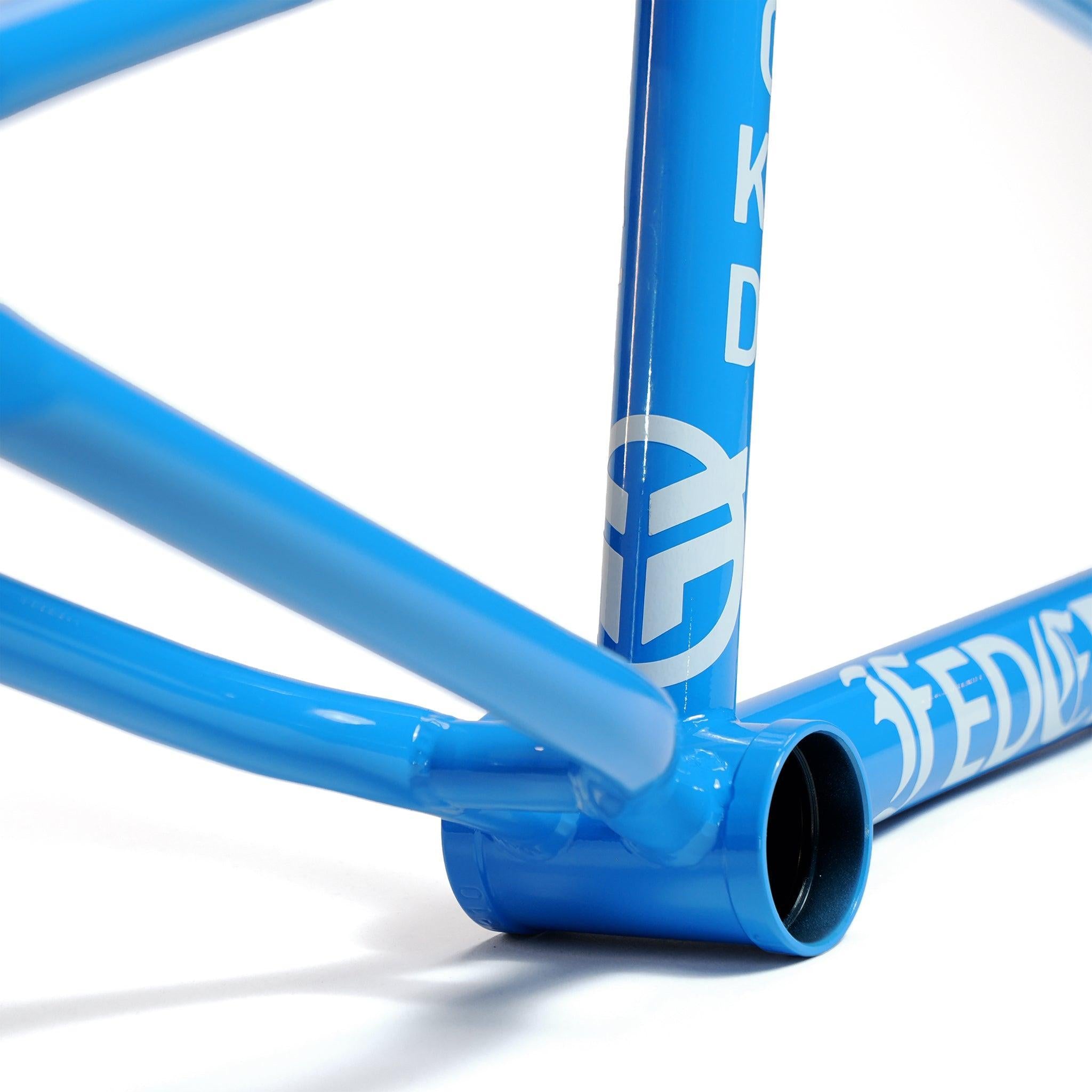 Close-up of the Federal Jarvis V2 BMX frame's blue bottom bracket area, featuring clean welds and a bold white logo on the metal tubing, showcasing its high-quality design for street riding.