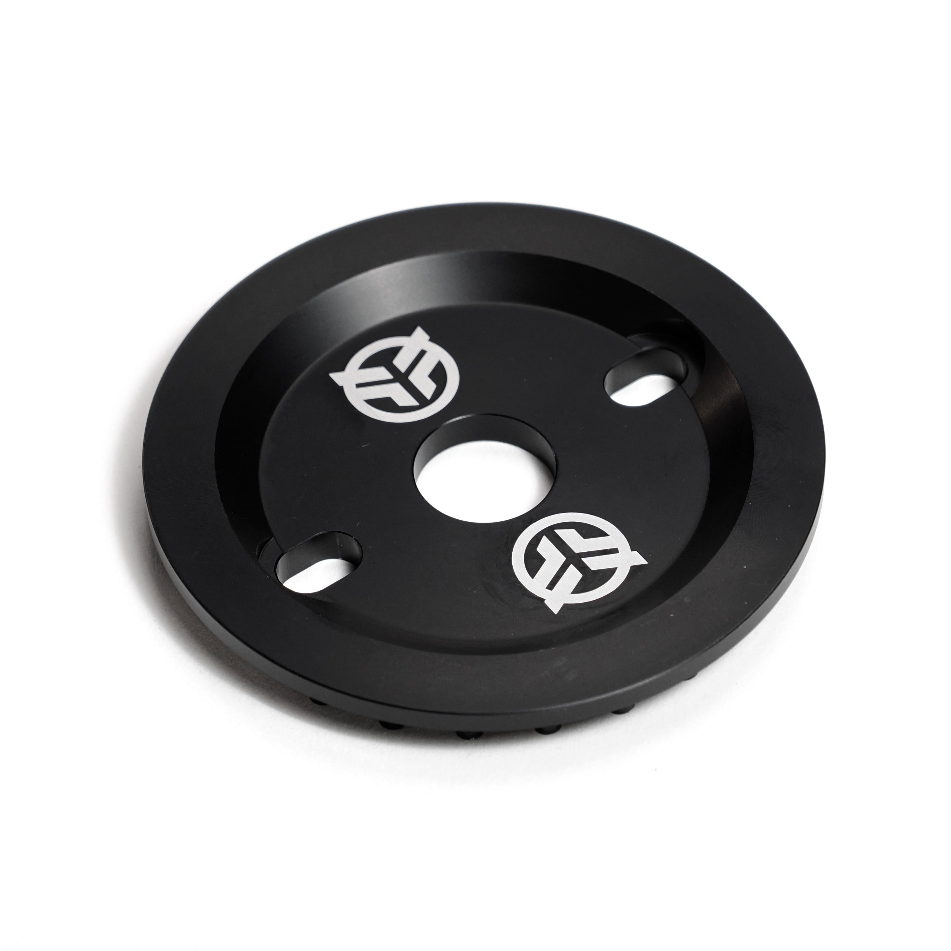 The Federal Code Guard Sprocket is a black circular metal guard sprocket with a central and two side holes, plus white geometric logos—ideal for protecting your BMX bike with added style.