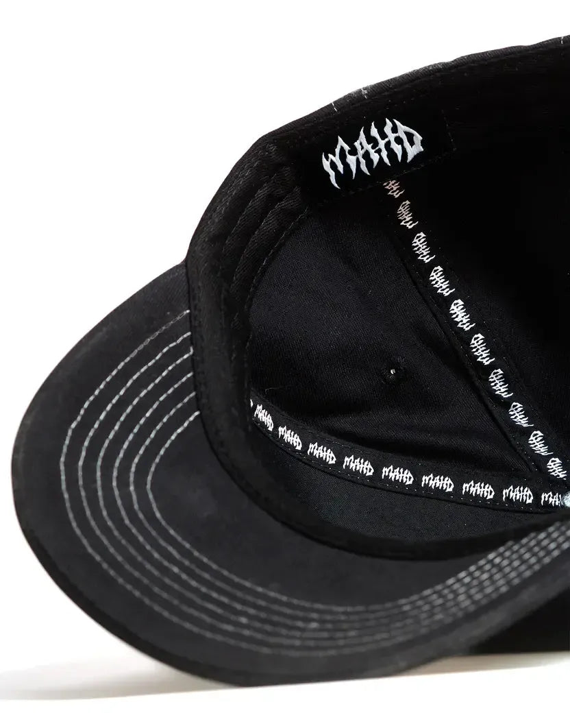 Close-up view of the inside of the black Mahd - Metal Hat, showing repeated white "MAHA" text on the sweatband and a single "MAHA" logo under the top panel.