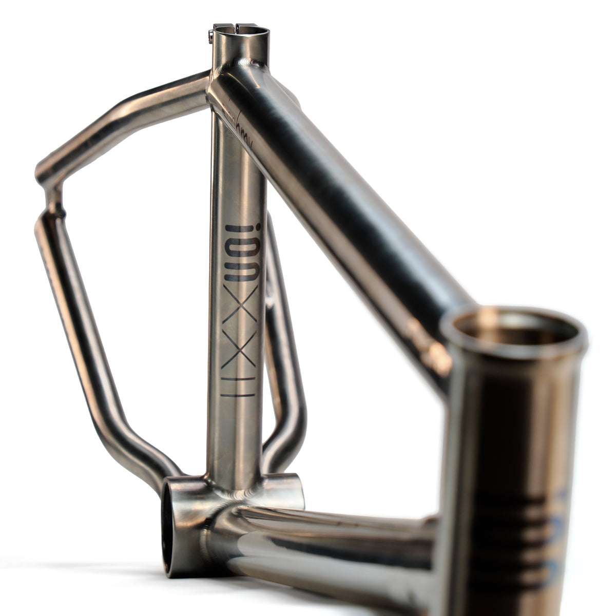 A close-up of the ION BMX Ti22 Titanium 22 Inch Frame highlights its minimalist metallic design, welded joints, TT-22 logo on the down tube, and precision-engineered 74° headtube angle.