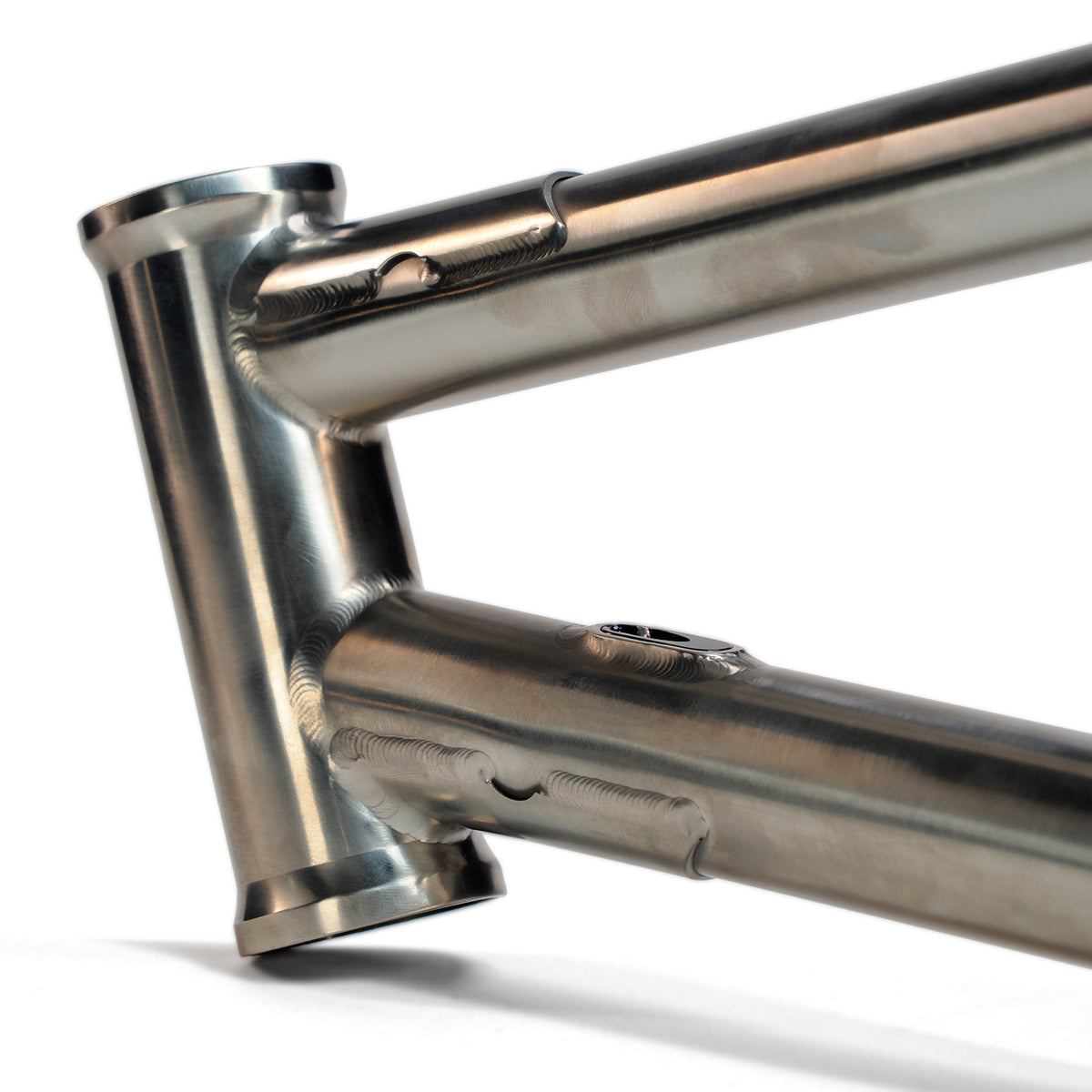 Close-up of the ION BMX Ti22 Titanium 22 Inch Frame, showcasing visible welds, a smooth polished finish, and a precise 74° headtube angle.