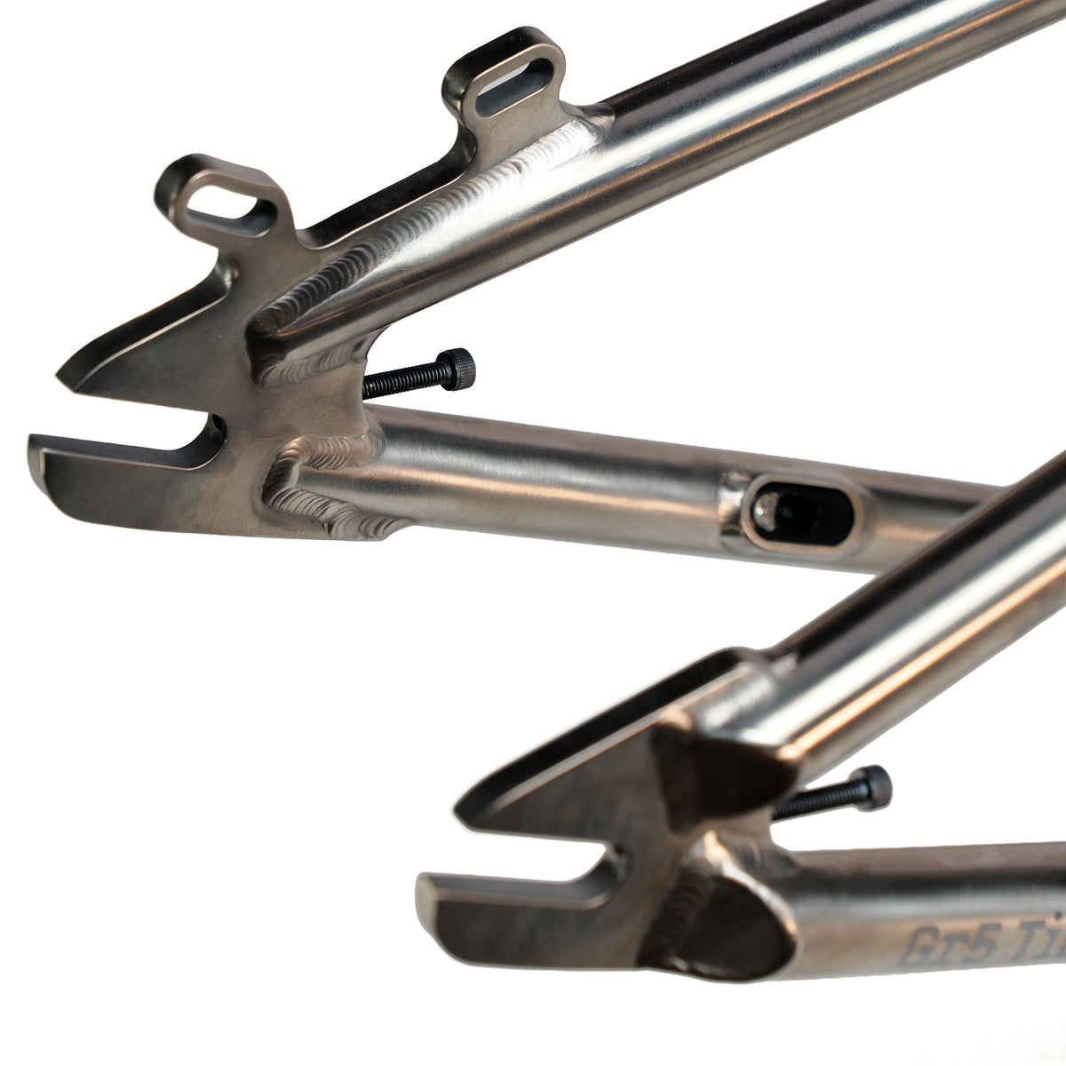Close-up of the ION BMX Ti22 Titanium 22 Inch Frame's rear dropout area, showcasing welds, mounting points, bolts, and its polished titanium surface.