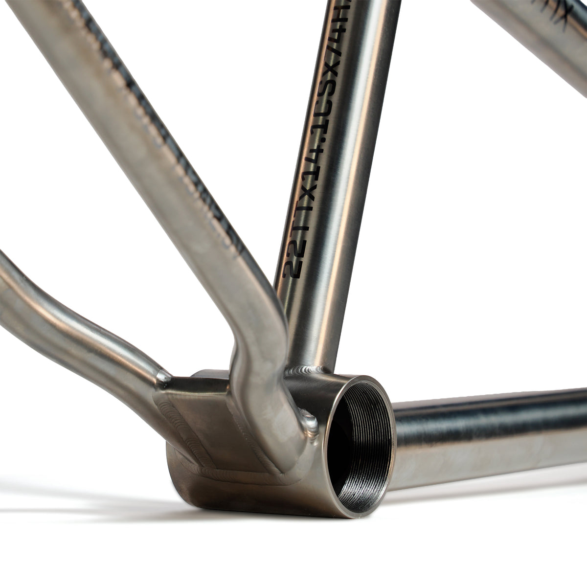 Close-up view of the ION BMX Ti22 Titanium 22 Inch Frame, focusing on the bottom bracket area with visible welds and "CS-14.1" engraved on the tube, showcasing its enhanced geometry details.