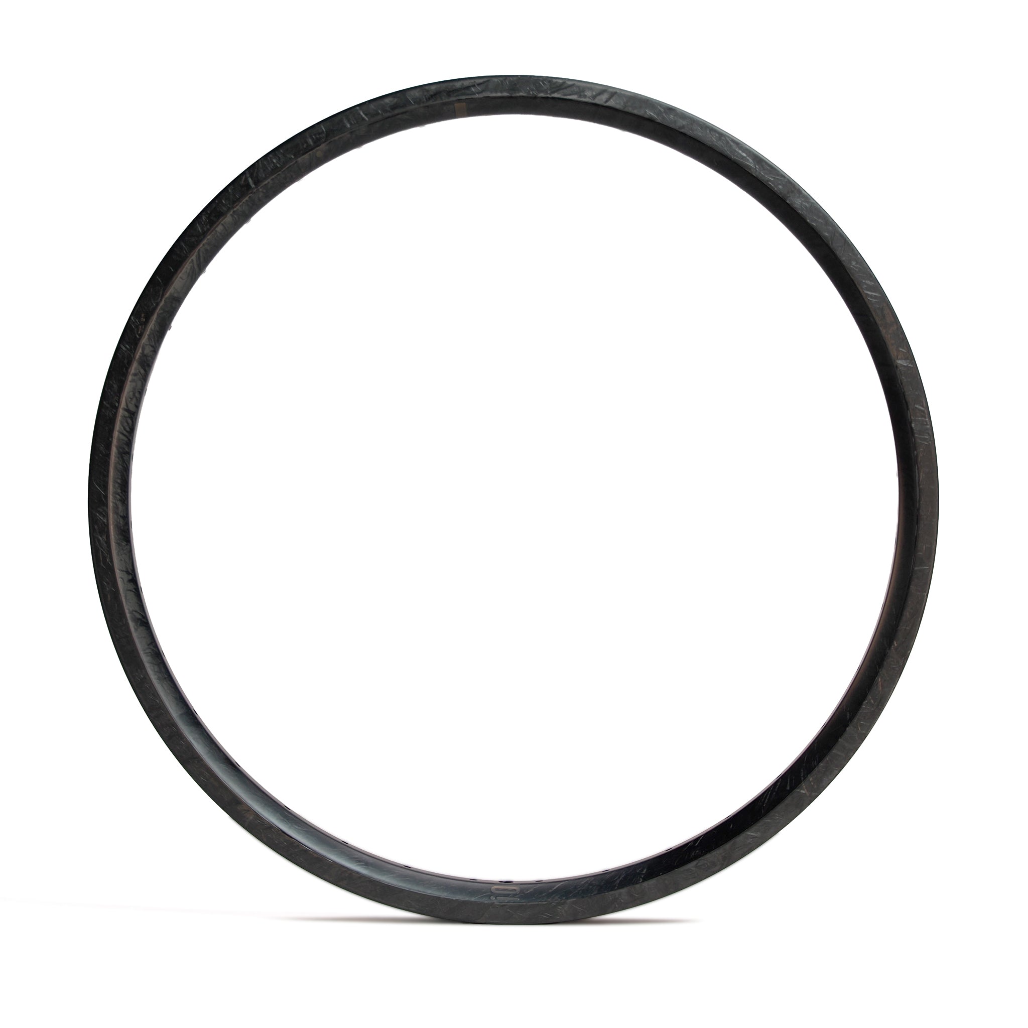 The ION BMX C22 Carbon Fiber 22 Inch Braking Rim, featuring a black, circular design with a textured surface, stands vertically against a plain white background.