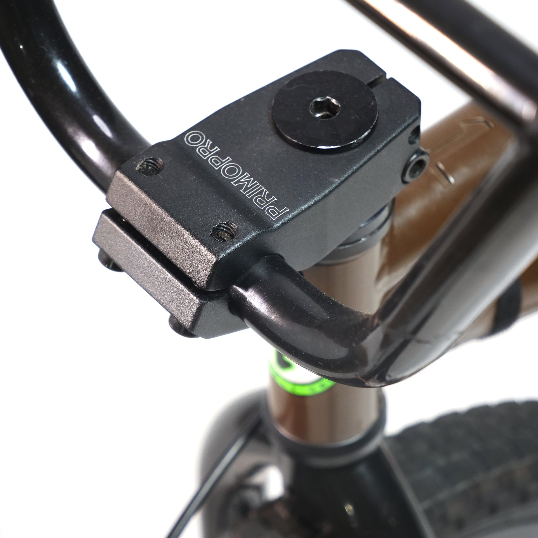 Close-up of a BMX handlebar and "PRIMO PRO" stem on a Terrible One Barcode Garrett Byrnes Custom 20 Inch Bike (2003), featuring a brown frame in the classic Barcode style and a visible black front tire.