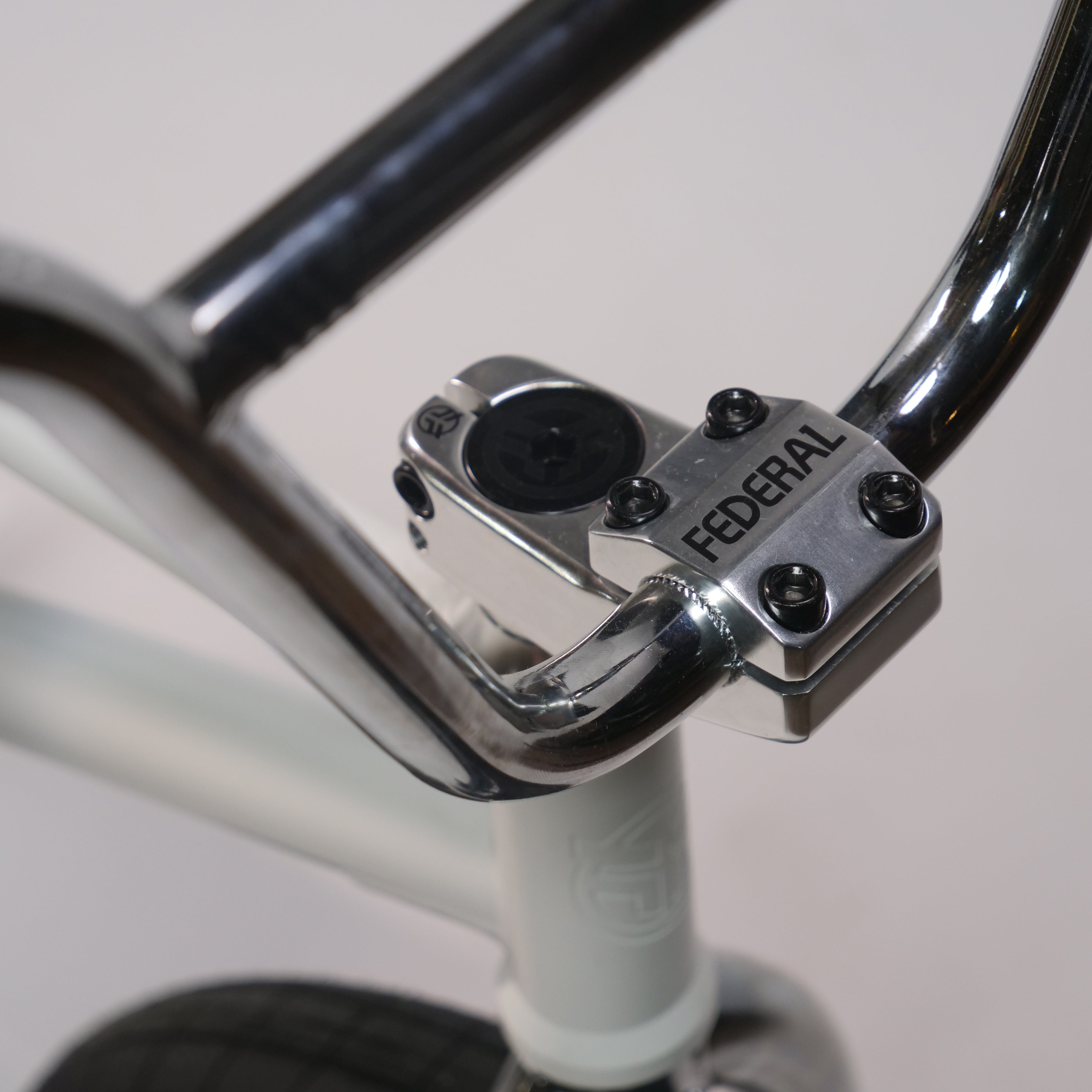 Close-up of the Federal Lacey x Chrome Custom 20 Inch Bike handlebar and stem with "FEDERAL" branding, mounted on a white frame for enhanced style and performance.