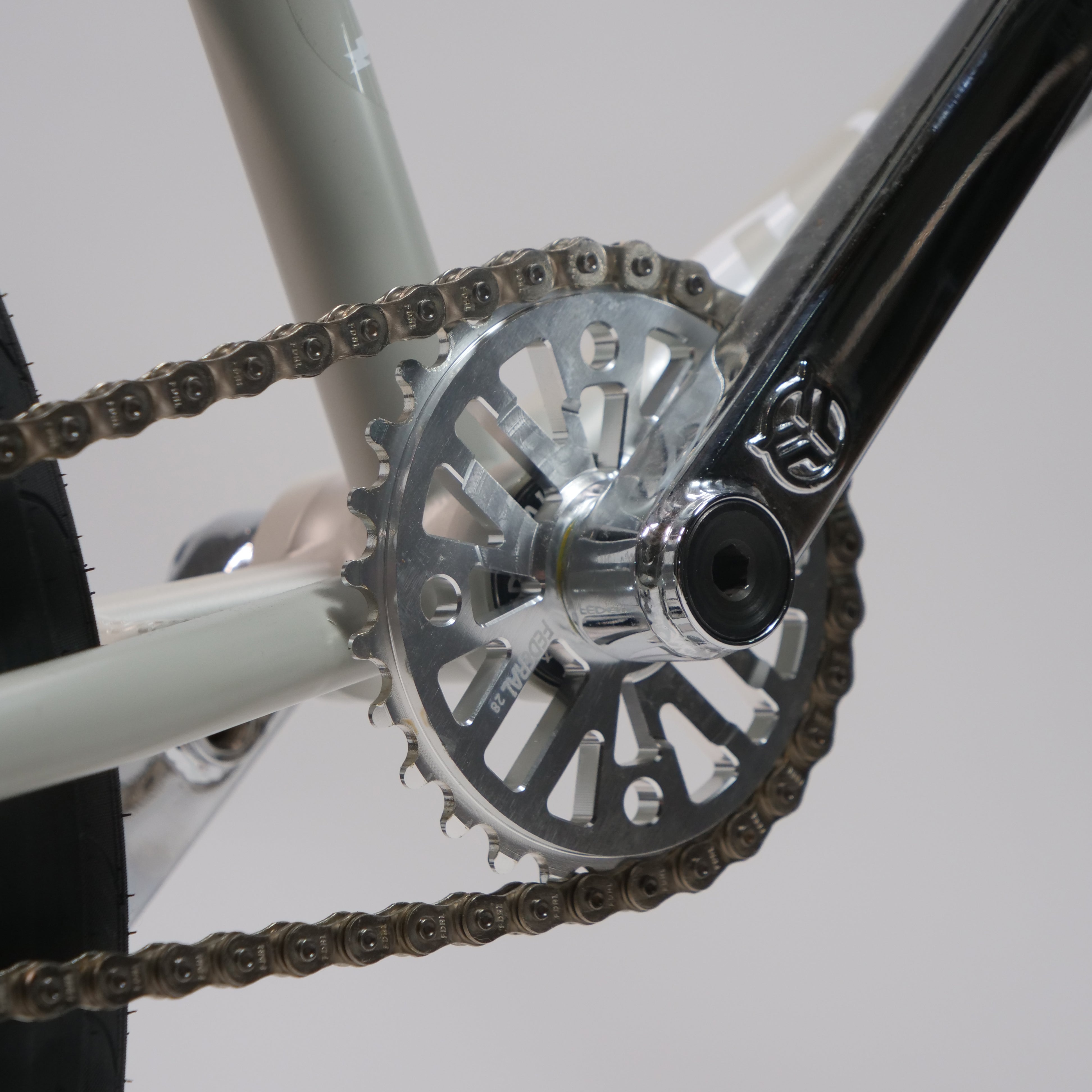 Close-up of the Federal Lacey x Chrome Custom 20 Inch Bike showing its crankset, silver chainring, crank arm, chain, and part of the rear tire.