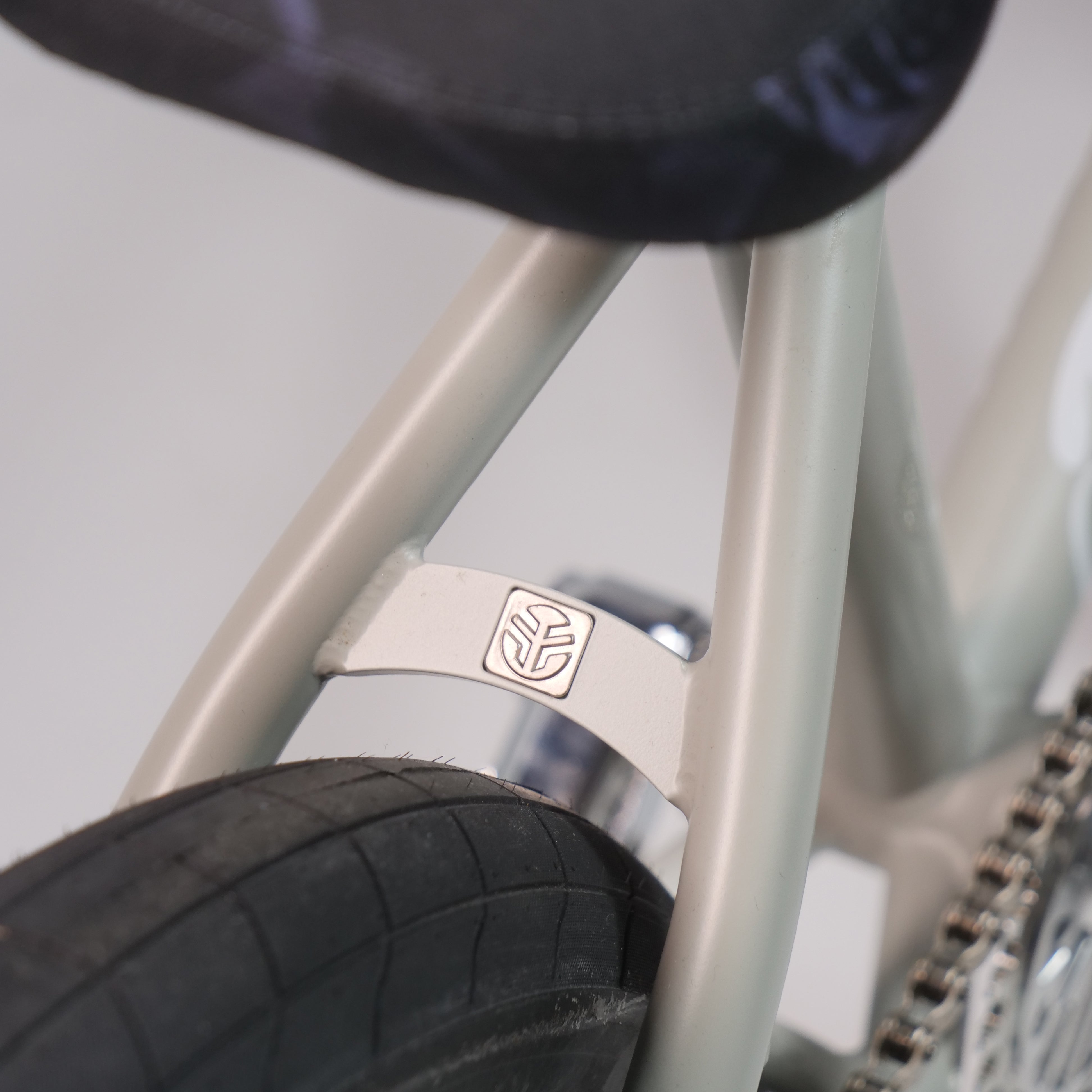 Close-up of the Federal Lacey x Chrome Custom 20 Inch Bike frame, showing the rear wheel, part of the seat, a small silver geometric emblem, and Federal Vice 2 Cranks for enhanced performance.