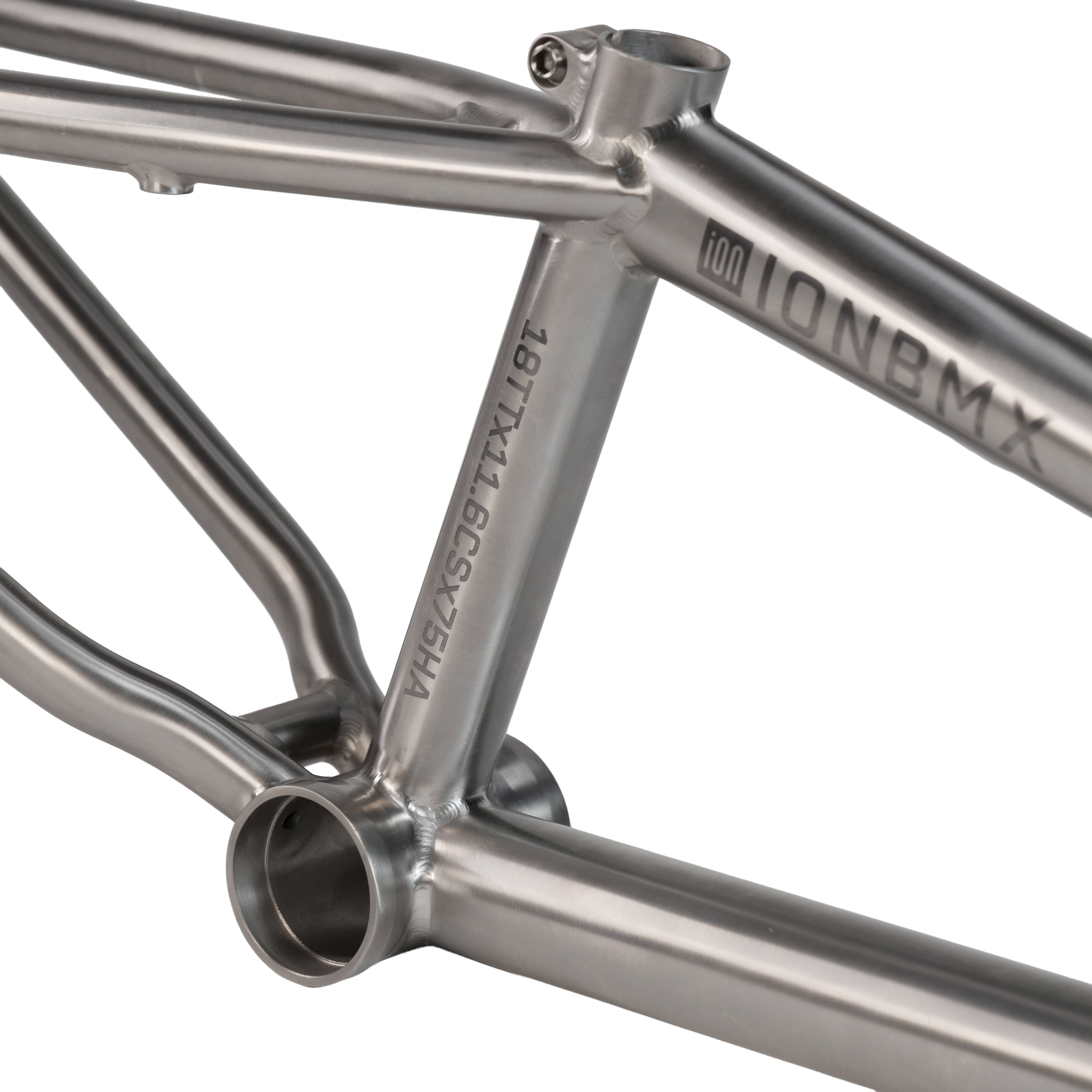 Close-up of the ION BMX Ti18 Titanium 18 Inch Frame, highlighting its silver titanium finish, detailed welds, bottom bracket area, and an engraved serial number on the seat tube.