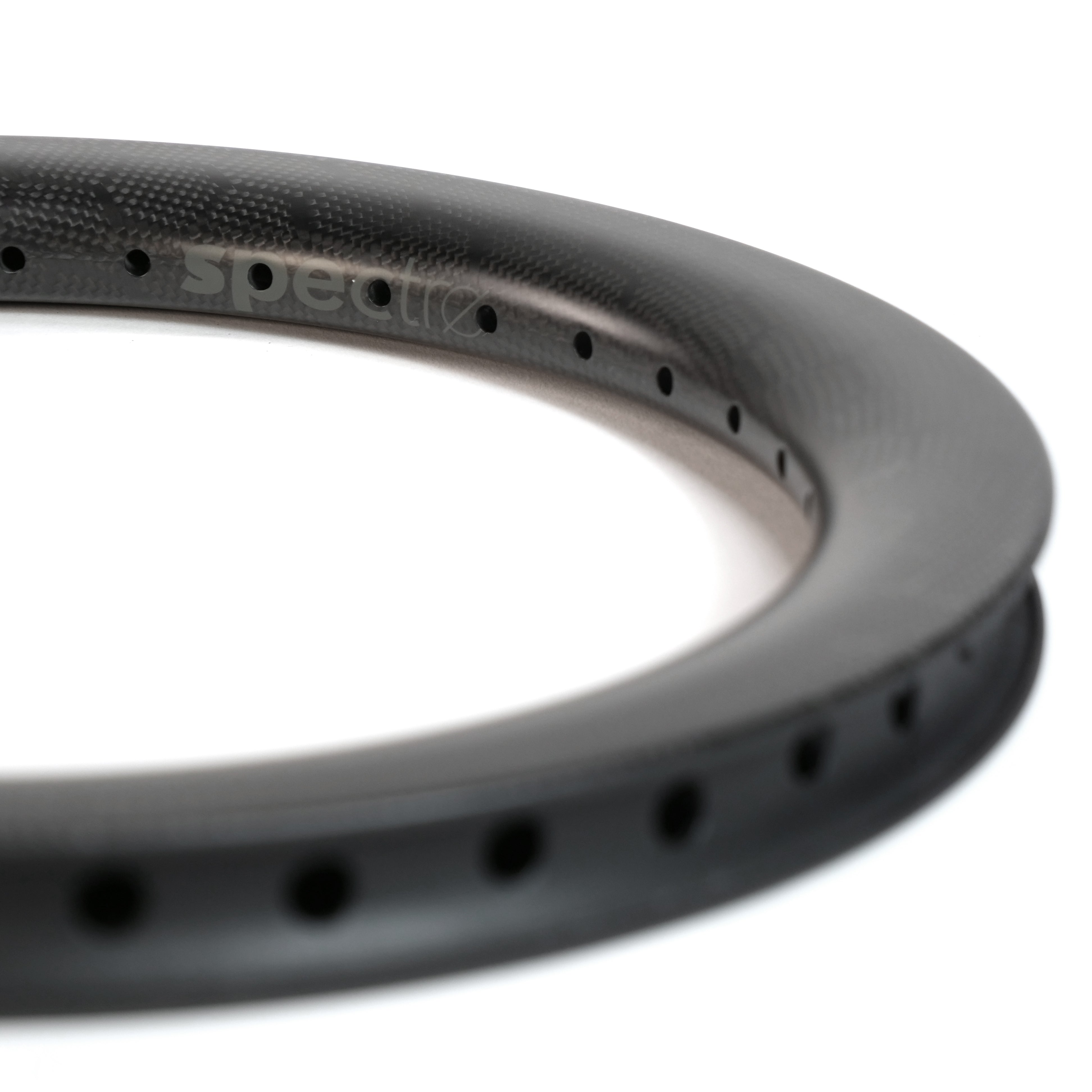 Close-up of the Spectre V2 Carbon Fiber 16 Inch 36H Brake Rim, featuring a matte black finish and evenly spaced spoke holes. The rim subtly displays the "spectre" branding.