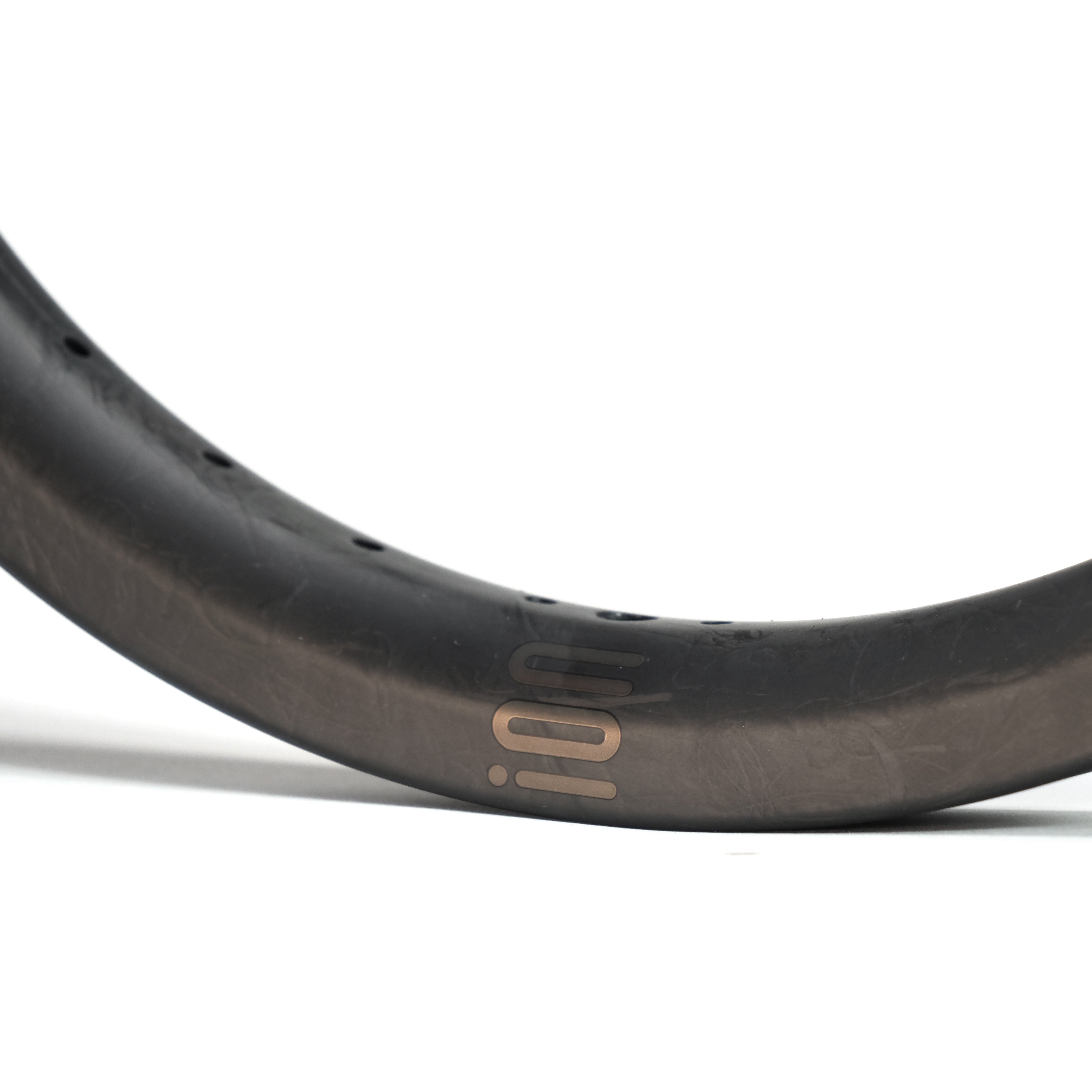 Close-up of the ION BMX C18 Carbon Fiber 18 Inch Brakeless Rim in black, featuring "100" in gold, crafted from Toray T800s carbon fiber, displayed against a white background.