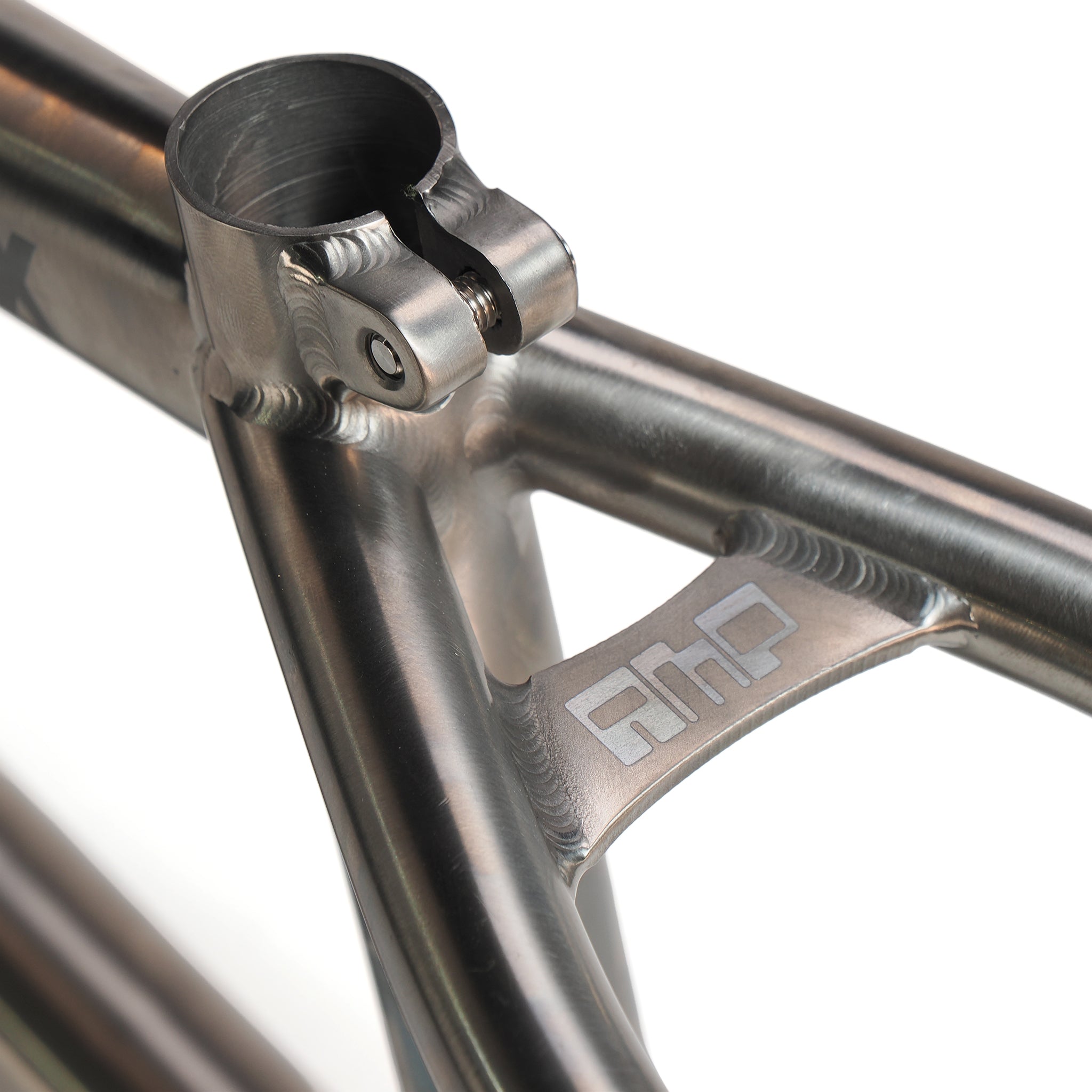 Close-up of the ION BMX AMP20 Titanium 20 Inch Frame, showing a metallic joint with clamp and engraved "ahp" logo on a support bracket—crafted from aerospace-grade titanium for top strength in this high-performance BMX frame.