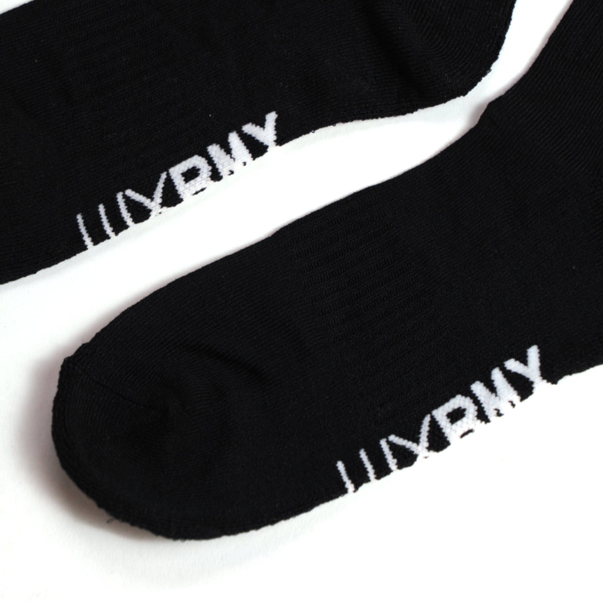 A close-up of two black LUXBMX Crew Socks featuring white "URBNY" text near the toes, displayed on a white background.