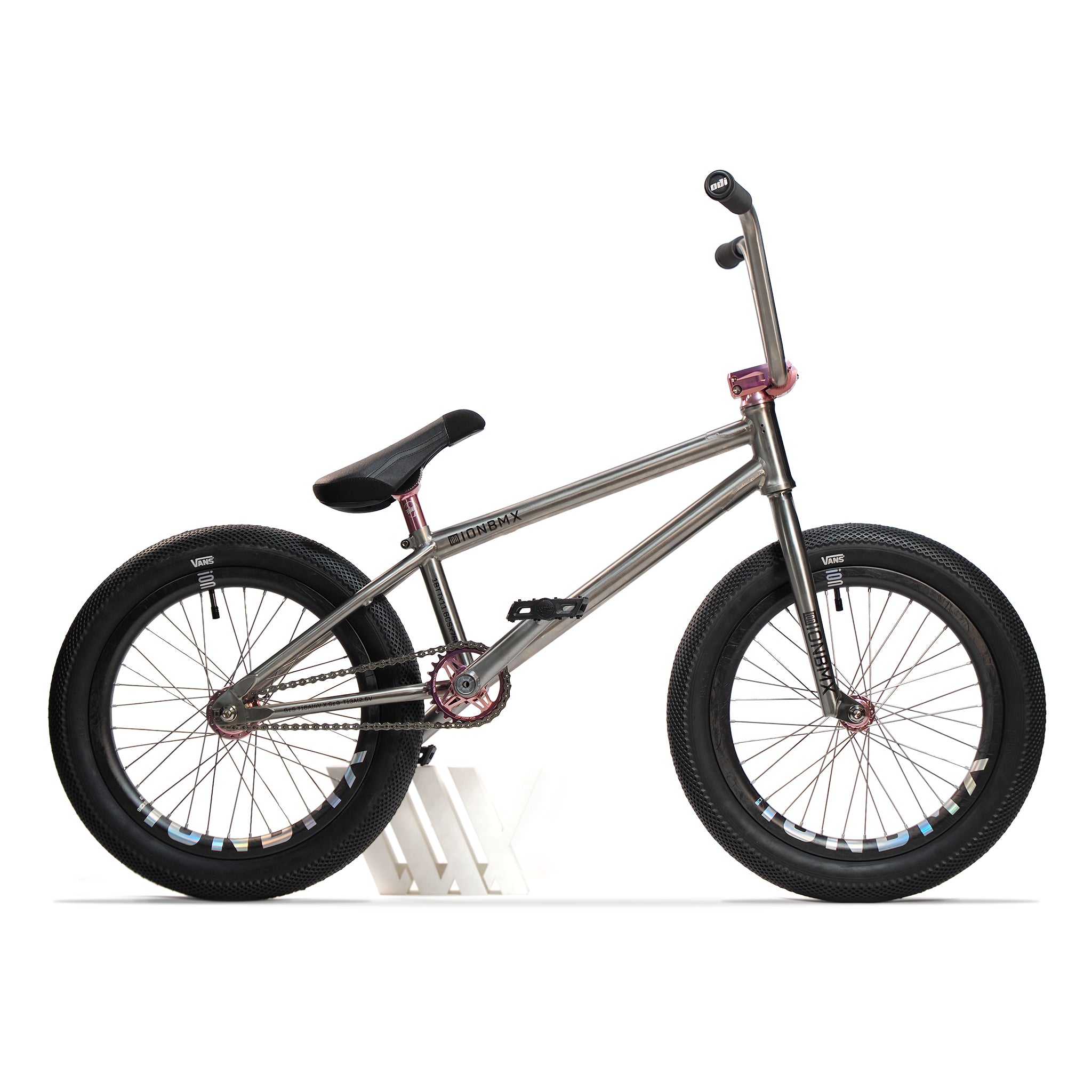 The ION BMX Ti18 Custom Titanium 18 Inch Bike, a lightweight freestyle model with black tires, black seat, and pink handlebar and fork accents, is displayed in side profile against a white background.