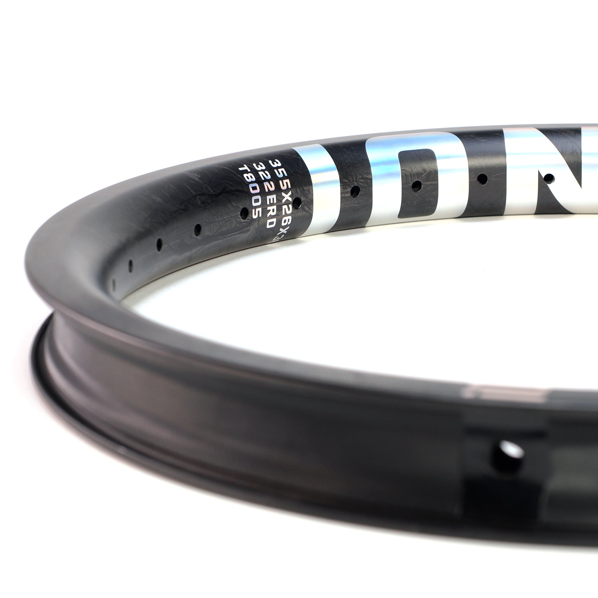 Close-up of the ION BMX C18 Carbon Fiber 18 Inch Brakeless Rim, made from premium Toray T800s carbon fiber, showing spoke holes and printed specs including size and model on the side—ideal for freestyle BMX.