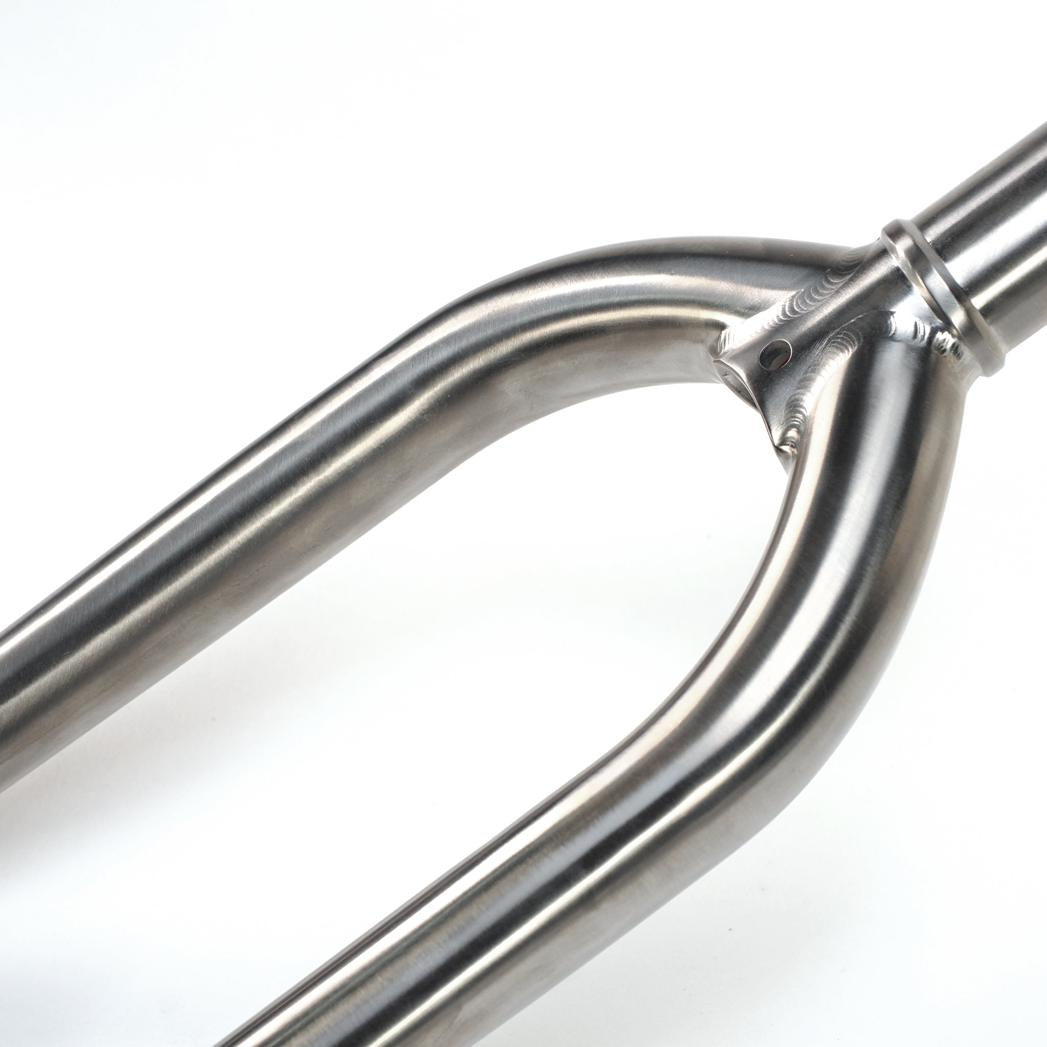 Close-up of the ION BMX Ti18 Titanium 18 Inch Forks, featuring a brushed metallic finish on the crown and steerer tube, isolated on a white background.