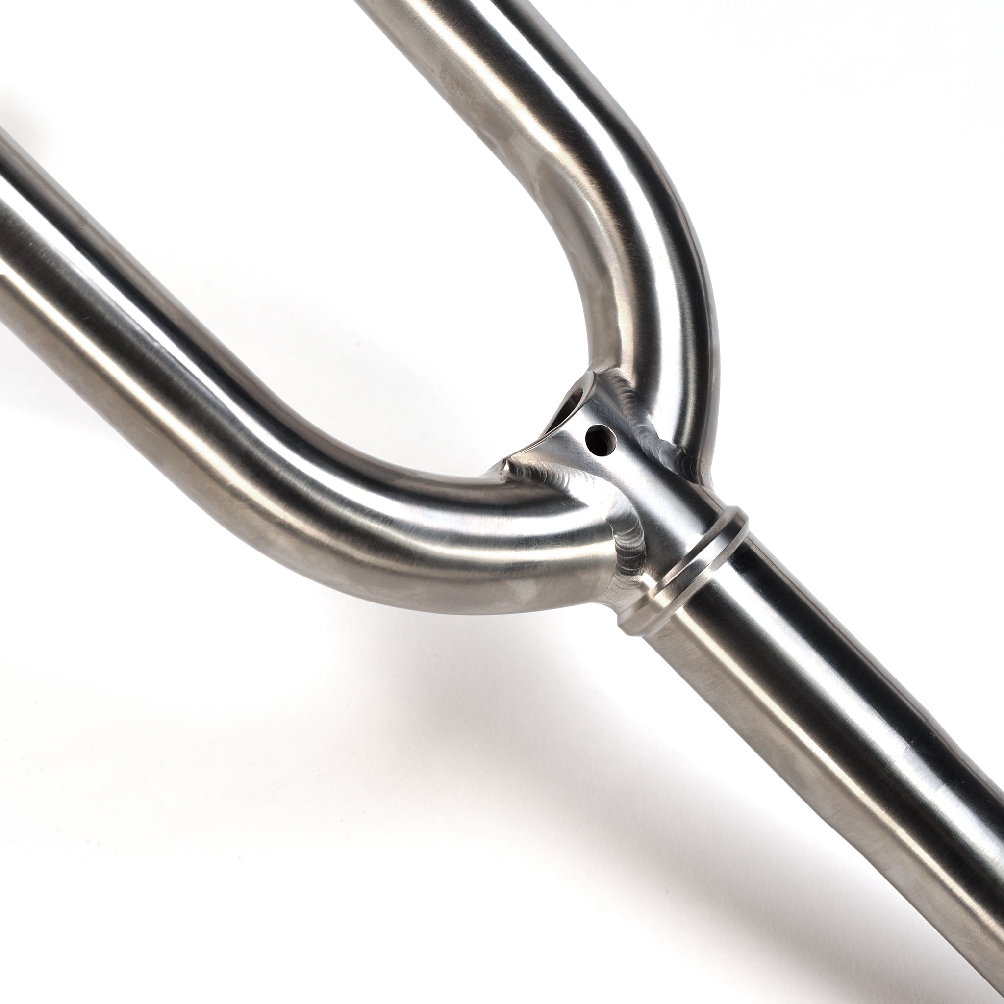 Close-up of the ION BMX Ti16 Titanium 16 Inch Forks featuring smooth welds and a hole near the joint, set against a white background.