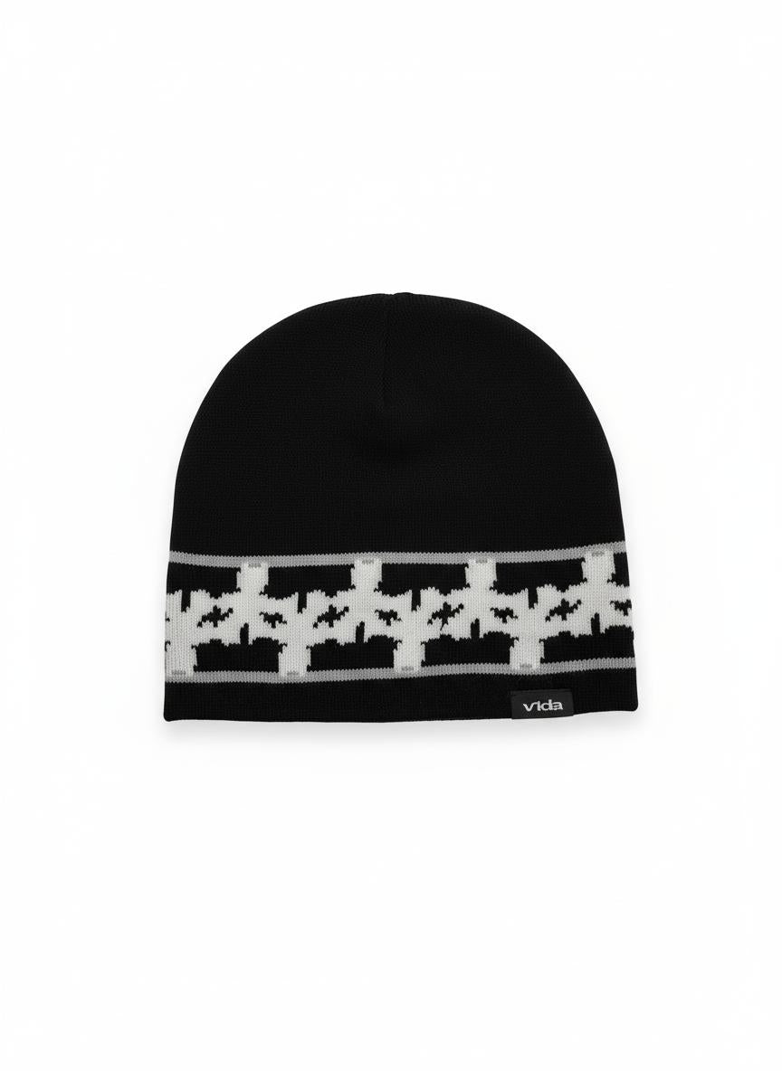 The V1da Pattern Beanie features a low fit in black, accented with a white houndstooth pattern band and a small "vida" label—your ideal go-to winter hat.