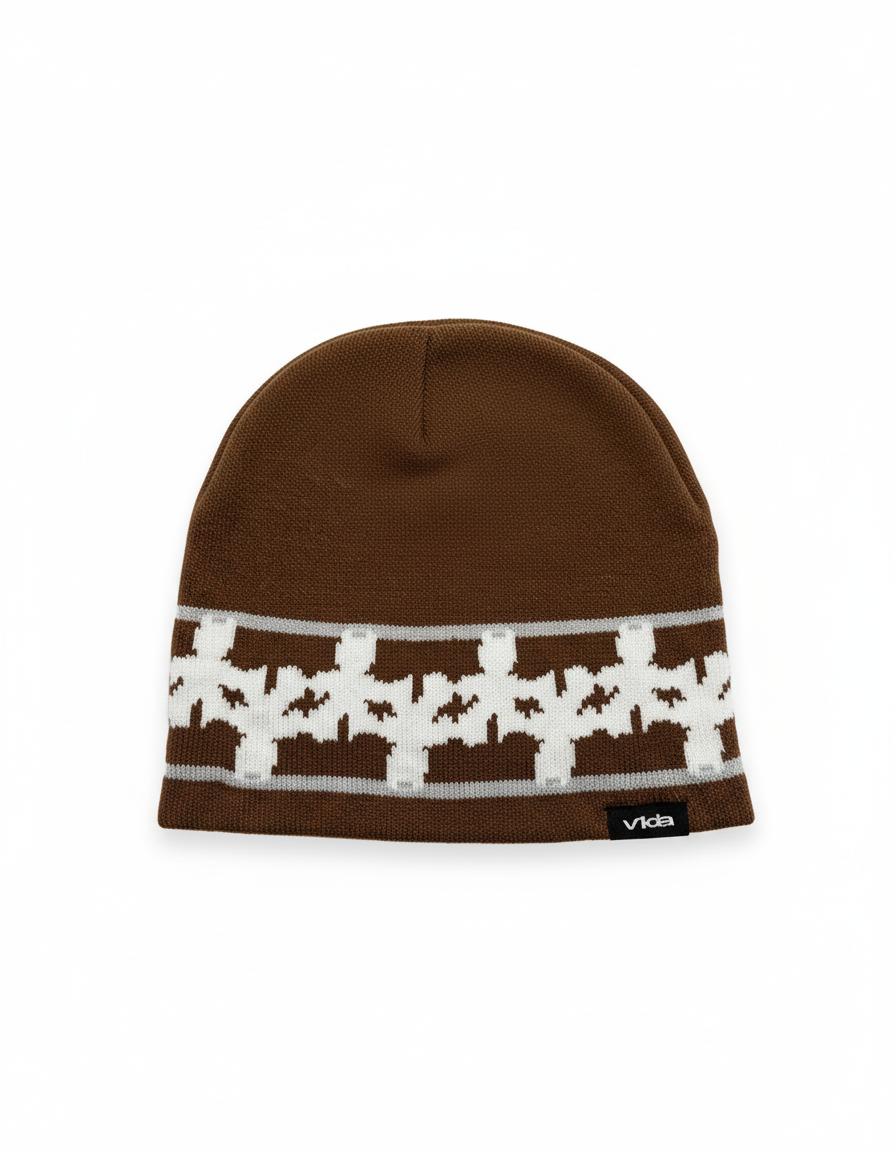 The V1da Pattern Beanie is a brown knit skully featuring a white geometric design and a black "Vida" tag on the bottom edge, shown against a white background.