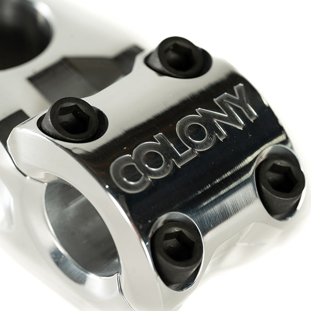 A Colony Variant 52mm BMX stem, featuring a chrome finish and the word "colony" engraved on it. This top load stem serves as a stylish and low-rise alternative for enhancing your BM.