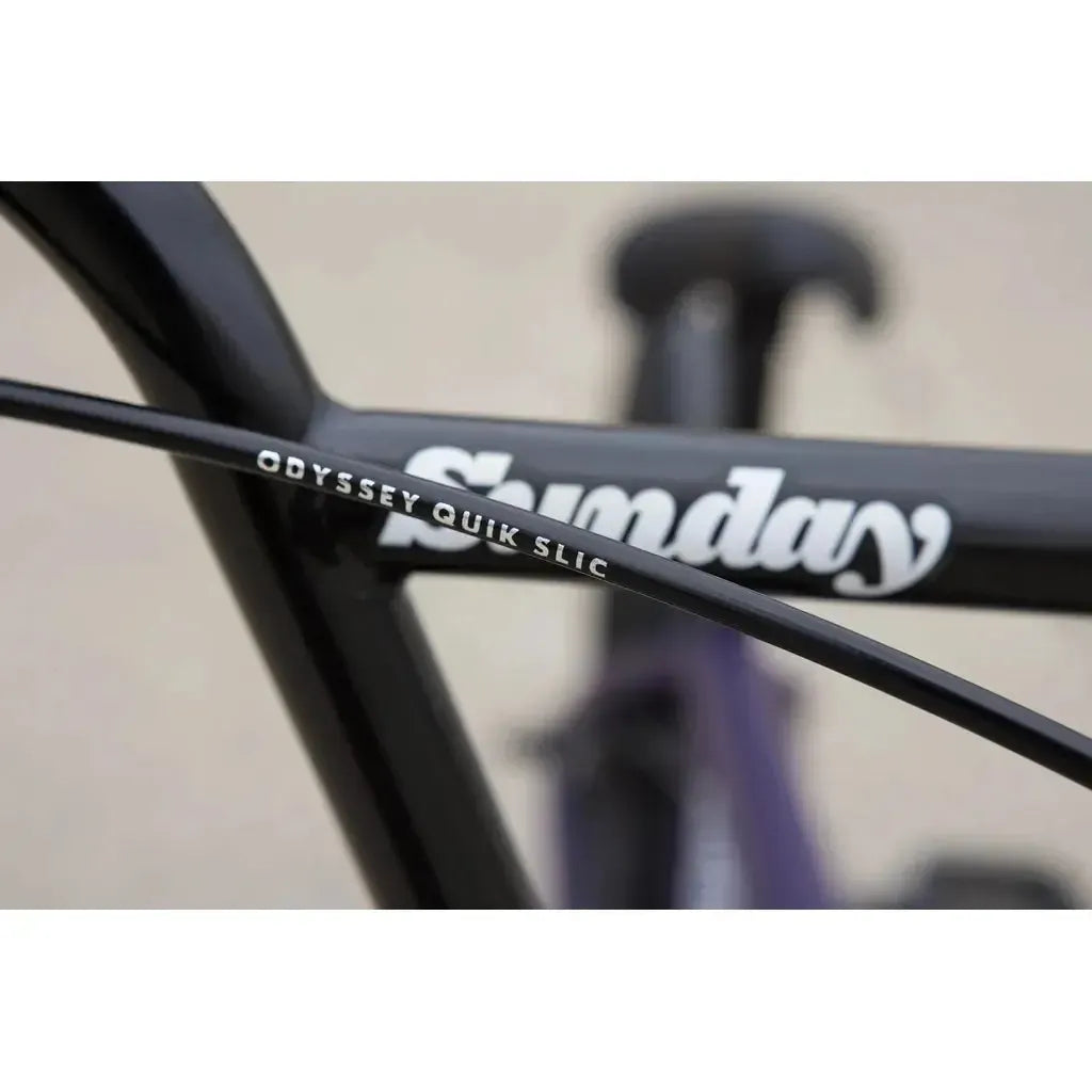 Close-up of the Sunday Primer 20 Inch Bike frame with the "Sunday" logo and Odyssey Quik Slic brake cable—an ideal choice for a beginner's or kid's BMX setup.