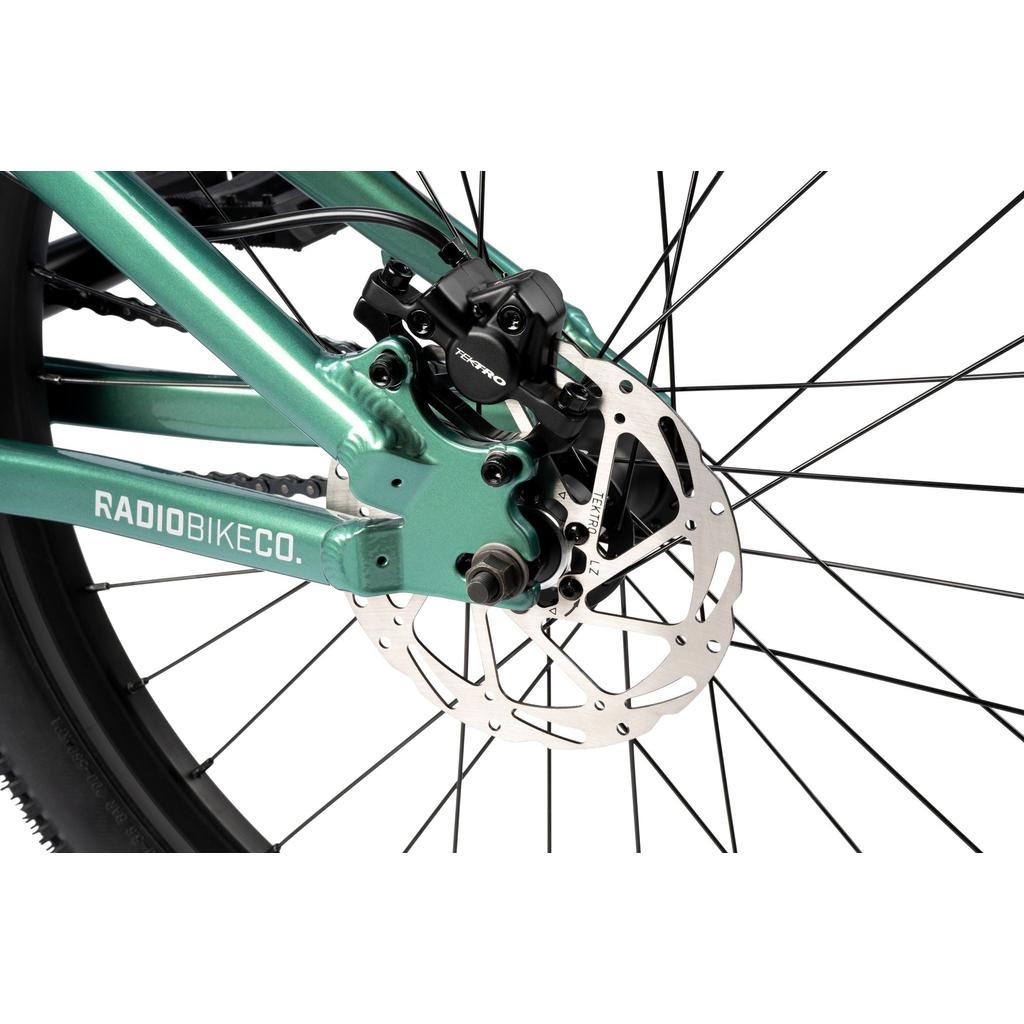 Close-up of the Radio Griffin 24 Inch Dirt Jumper Bike's rear disc brake system, highlighting the caliper, rotor, wheel spokes, and part of the frame.