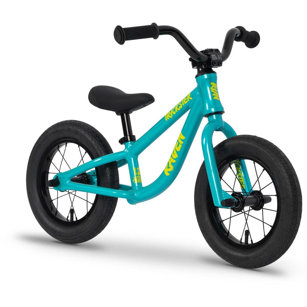 The Raven Trickster Alloy 12 Inch Balance Bike features a turquoise lightweight alloy frame, black handlebars, seat, and tires, with yellow "Raven" branding on the frame.