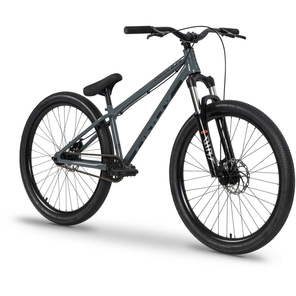 The Raven Onyx 26 Inch Dirt Jumper Bike, featuring a gray Chromoly frame, thick black tires, front suspension fork, flat handlebars, single gear, and disc brakes, is displayed on a white background.