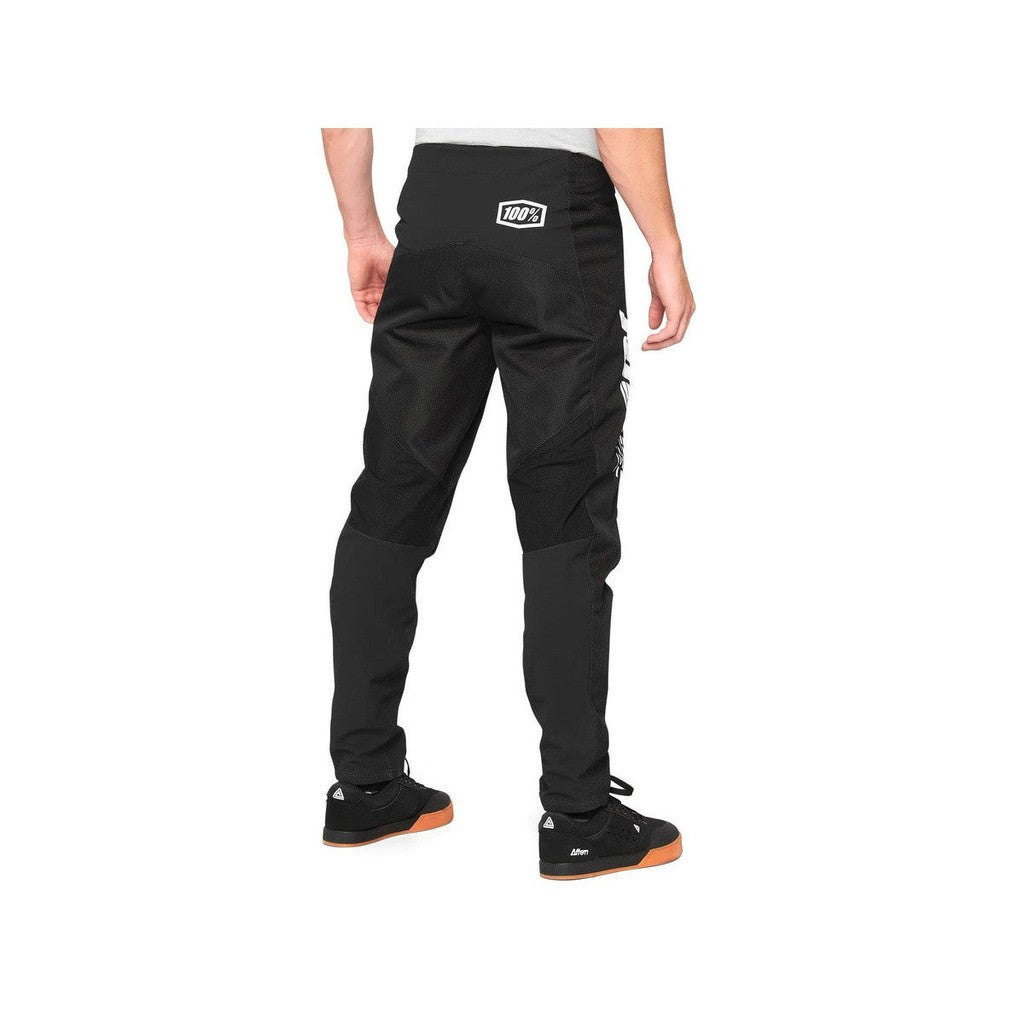 The back view of a man wearing 100% R-Core Youth Race Pants.