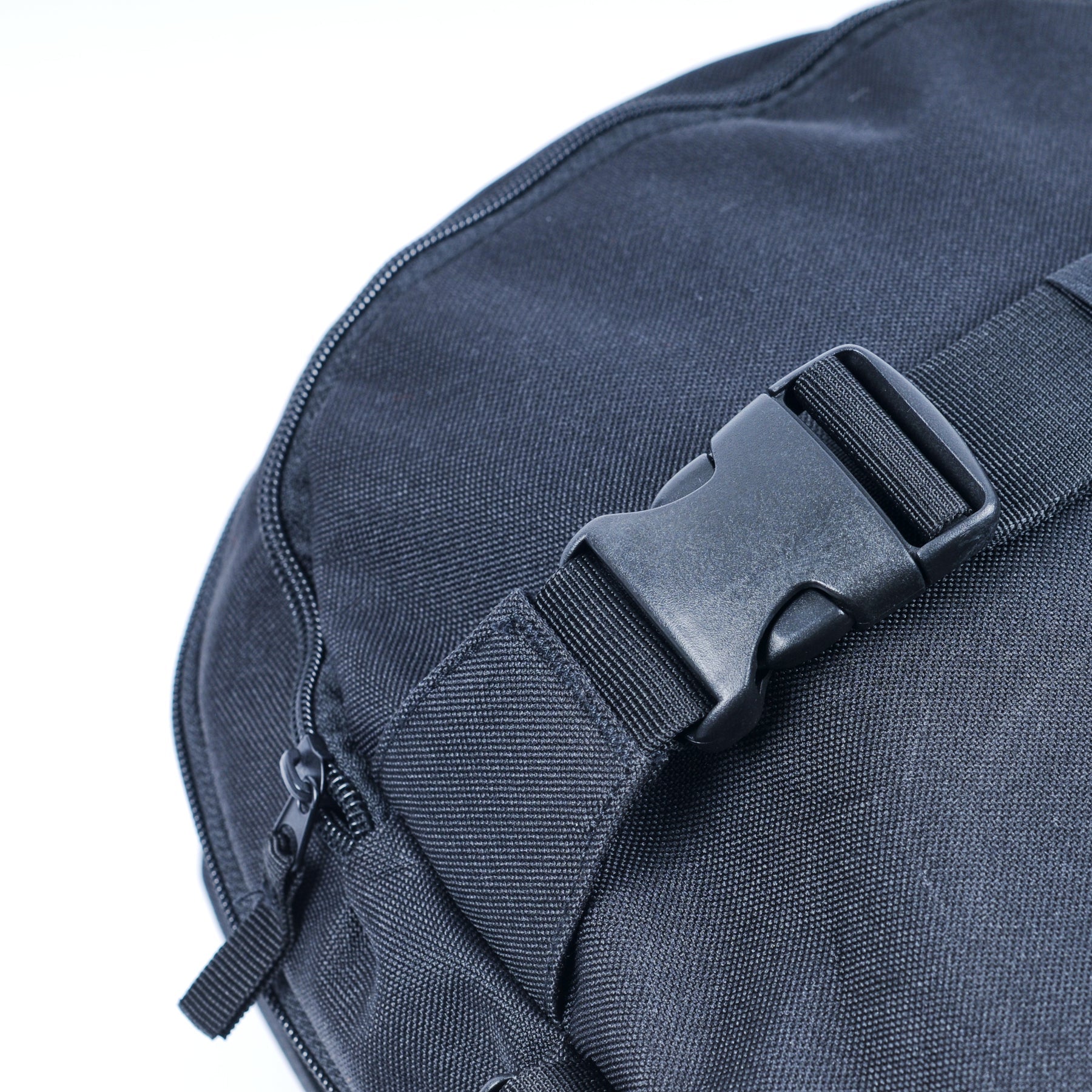 Close-up of the United Dayward Backpack in black, featuring a plastic side-release buckle, zipper, and skateboard carry straps against a white background.