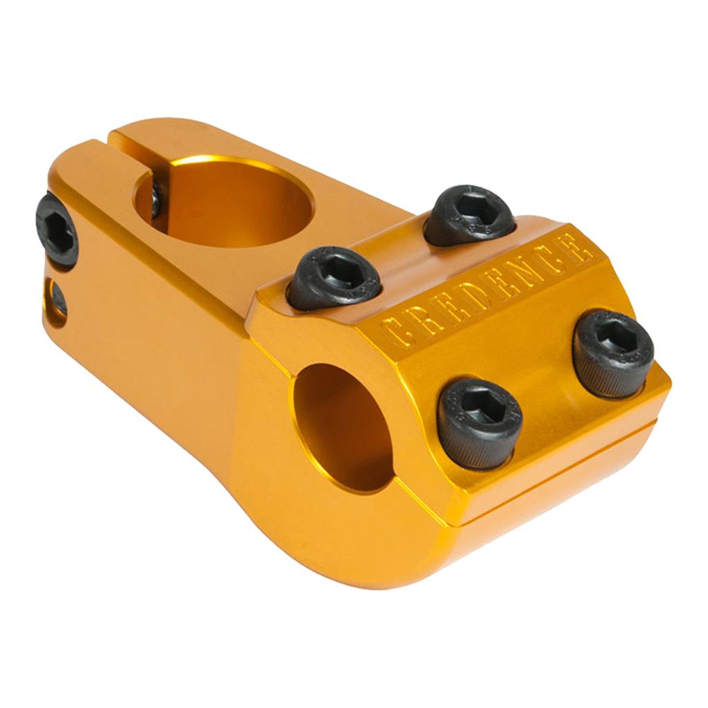 Gold-colored S&M Turtleneck Stem (22.2mm Clamp) BMX stem with a 52mm reach, featuring four black bolts on the front, two black bolts on the side, and “CREDENCE” engraved on the front face.