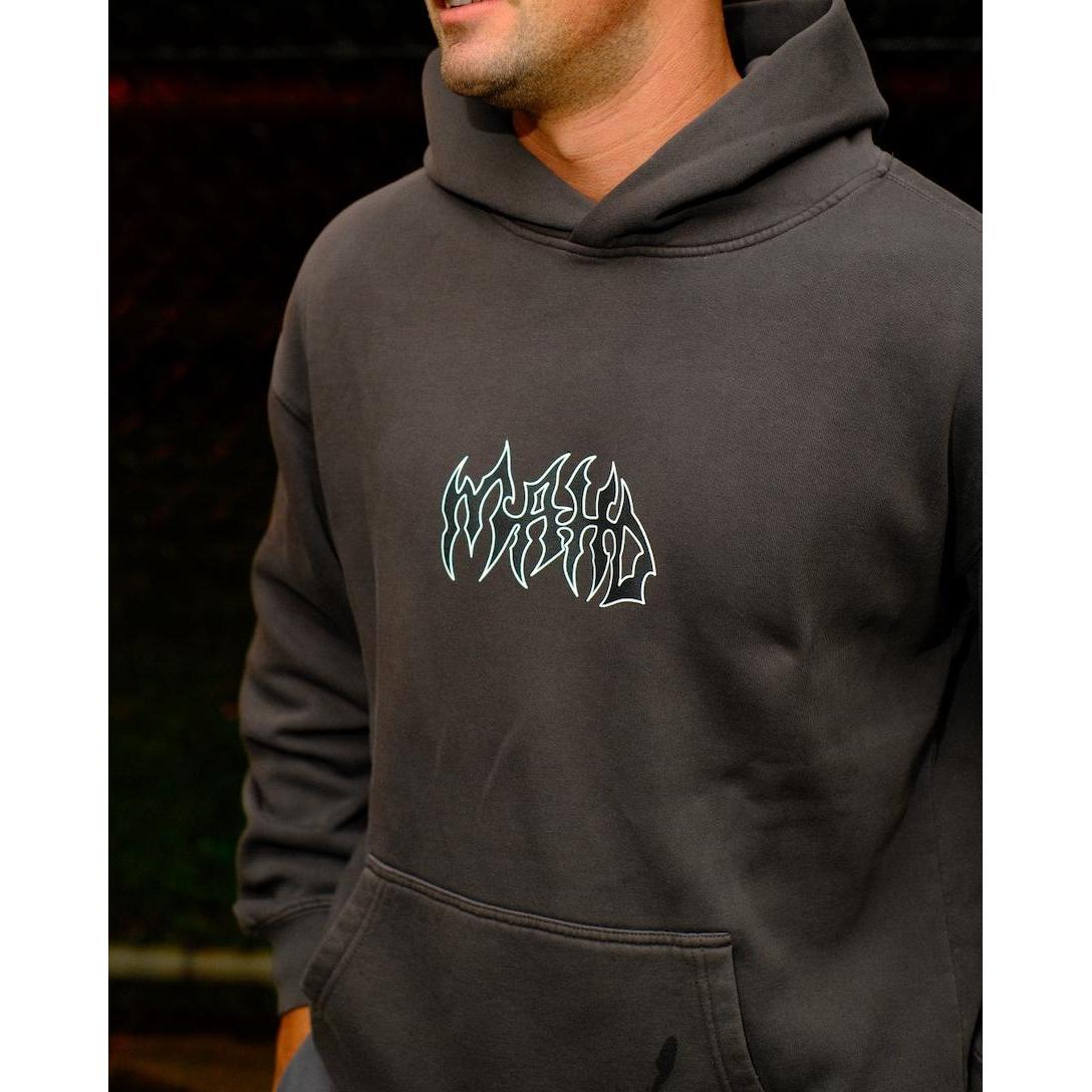 A person wearing the Mahd Metal Hoodie, a dark gray hoodie featuring a stylized white graphic design on the chest, standing outdoors.