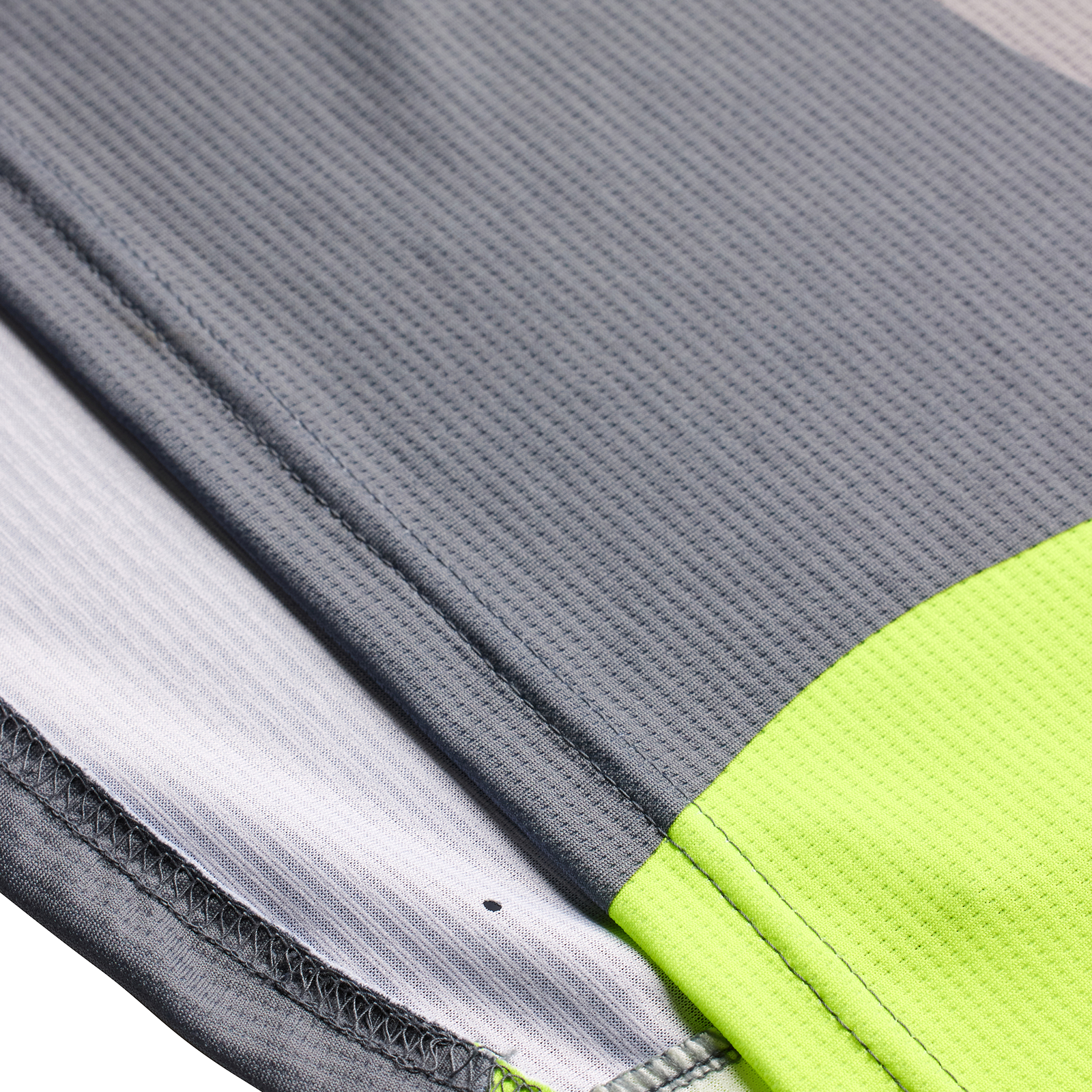 Close-up of TLD Youth Sprint Jersey Reverb Charcoal sports fabric layers with a neon green accent.