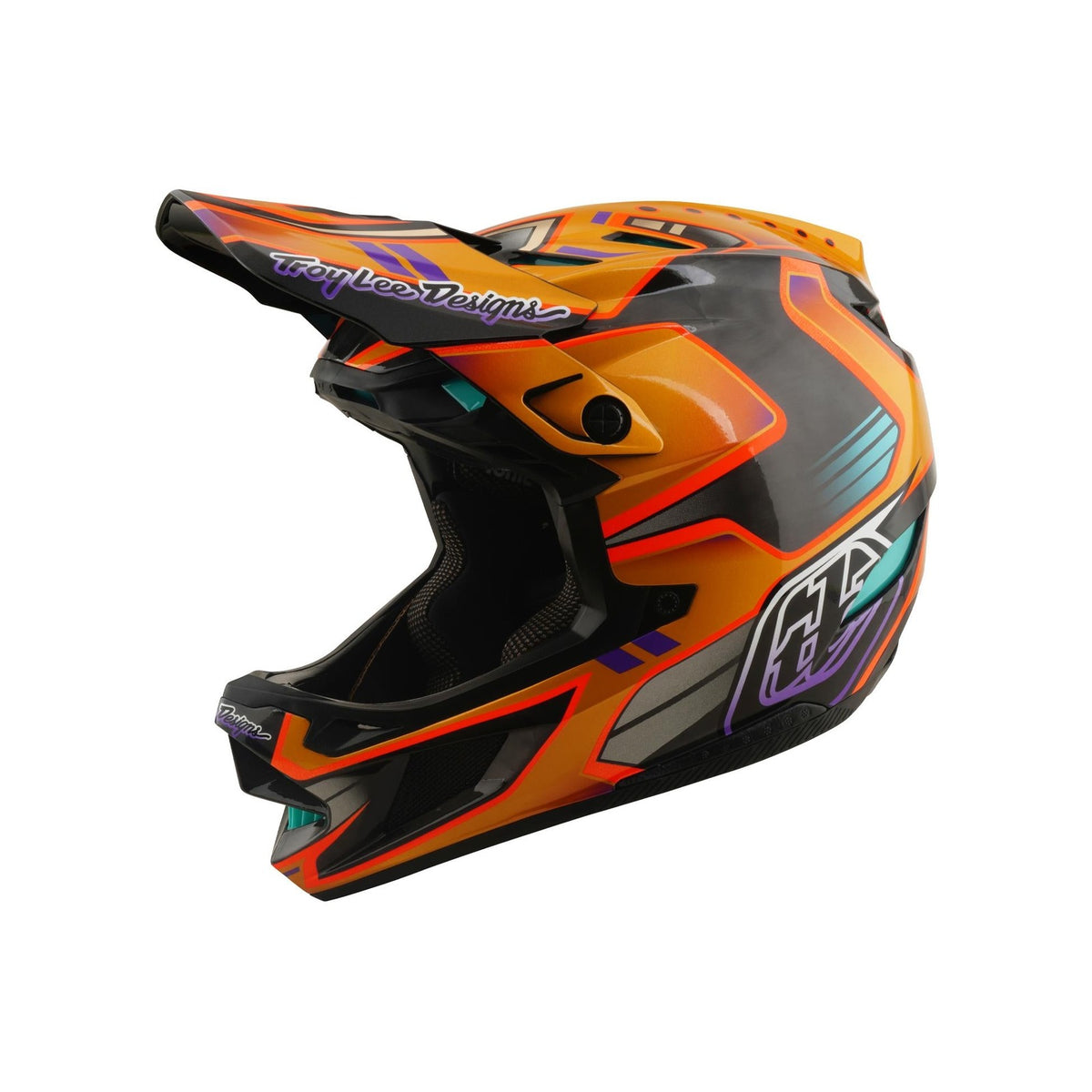 The TLD 26.1 D4 AS Carbon Helmet / Crest Gold is a full-face mountain biking helmet featuring orange and black geometric patterns, teal and purple accents, Troy Lee Designs branding, and advanced Mips safety protection.