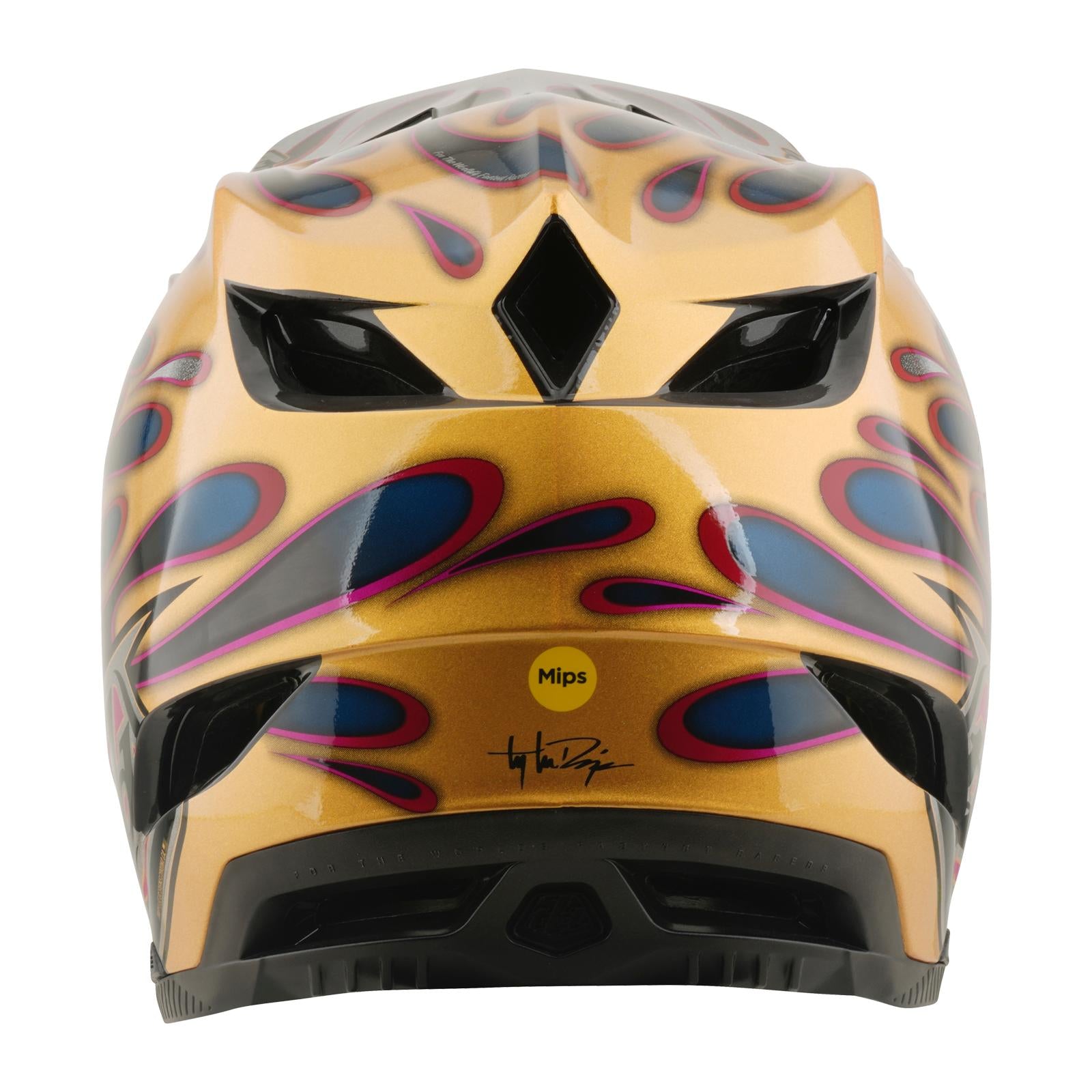 A rear view of the TLD 26.1 D4 AS Carbon Helmet in Overspray Gold/Black, featuring blue and red flame-like designs, black vents, a yellow Mips sticker, and a printed signature.