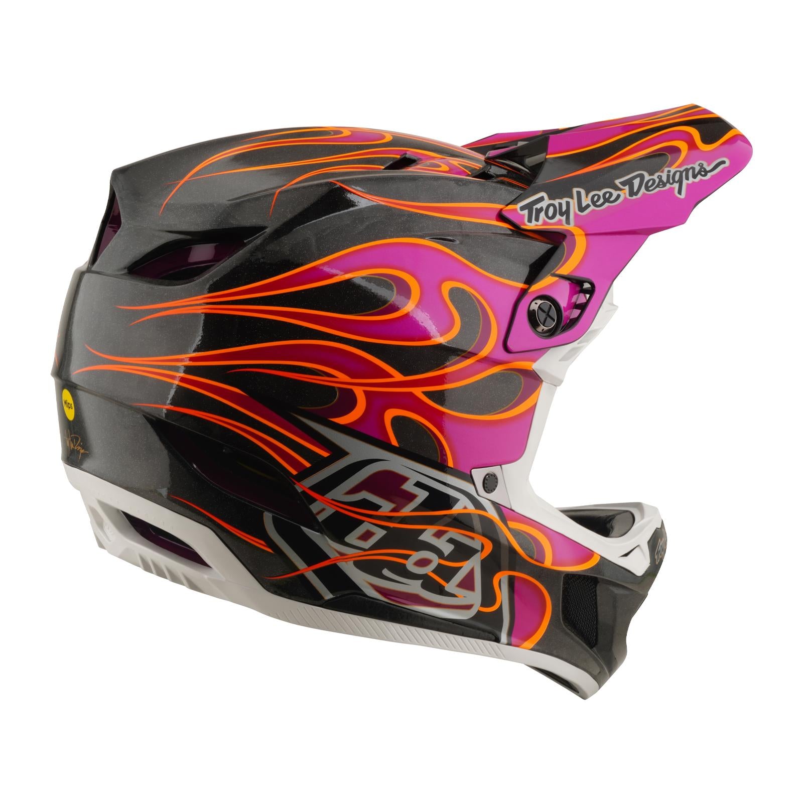 Side view of the TLD 26.1 D4 AS Carbon Helmet in Torched Carbon/Magenta with black, white, pink, and orange flame accents, "Troy Lee Designs" on the visor, and a lightweight carbon fiber shell for top safety.