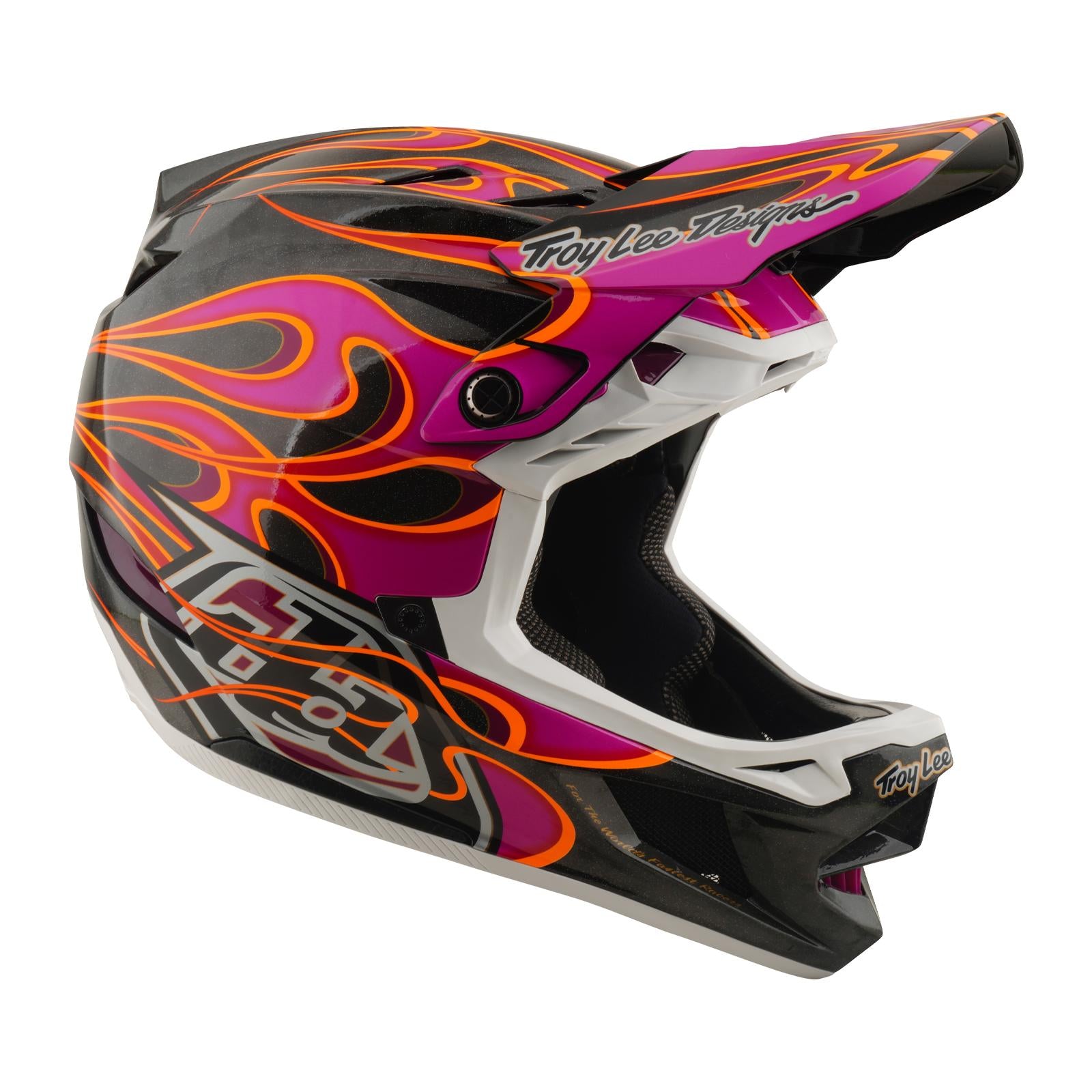 The TLD 26.1 D4 AS Carbon Helmet in Torched Carbon/Magenta features a full-face design, black base with pink and orange flame graphics, Mips protection, and Troy Lee Designs branding on the visor and chin.