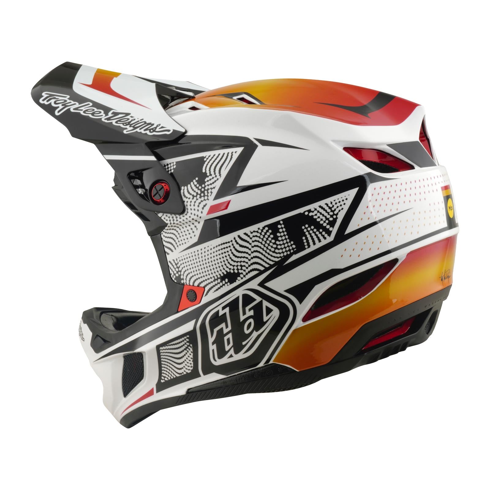 The TLD 26.1 D4 AS Composite Helmet / Lined Up White features a white, black, and orange geometric design, "Troy Lee Designs" on the visor, ventilation gaps, and Mips protection for safety during intense motocross rides.