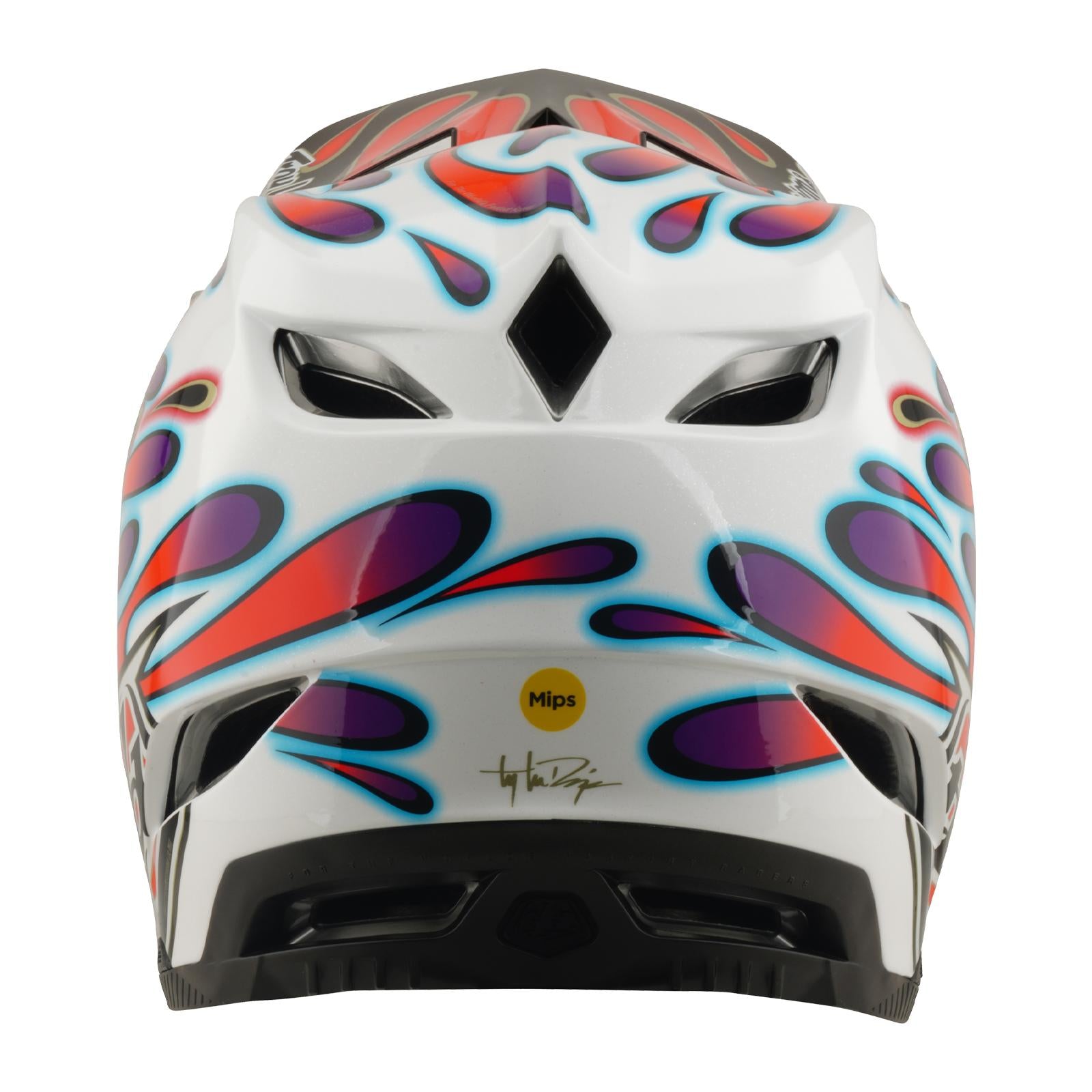 The TLD 26.1 D4 AS Composite Helmet in Overspray White/Red is a white BMX helmet with blue, purple, and red flame-like designs, rear ventilation slots, and features a "Mips" protection sticker.
