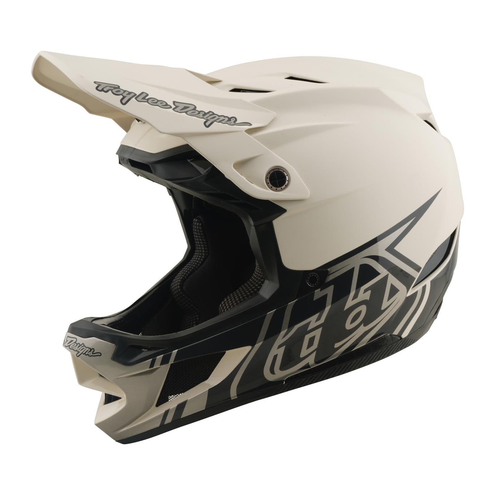 The TLD 26.1 D4 AS Composite Helmet in Stealth Pumice is a beige and black BMX helmet with an open face, angular graphics, visor, and advanced Mips protection for enhanced durability and safety.