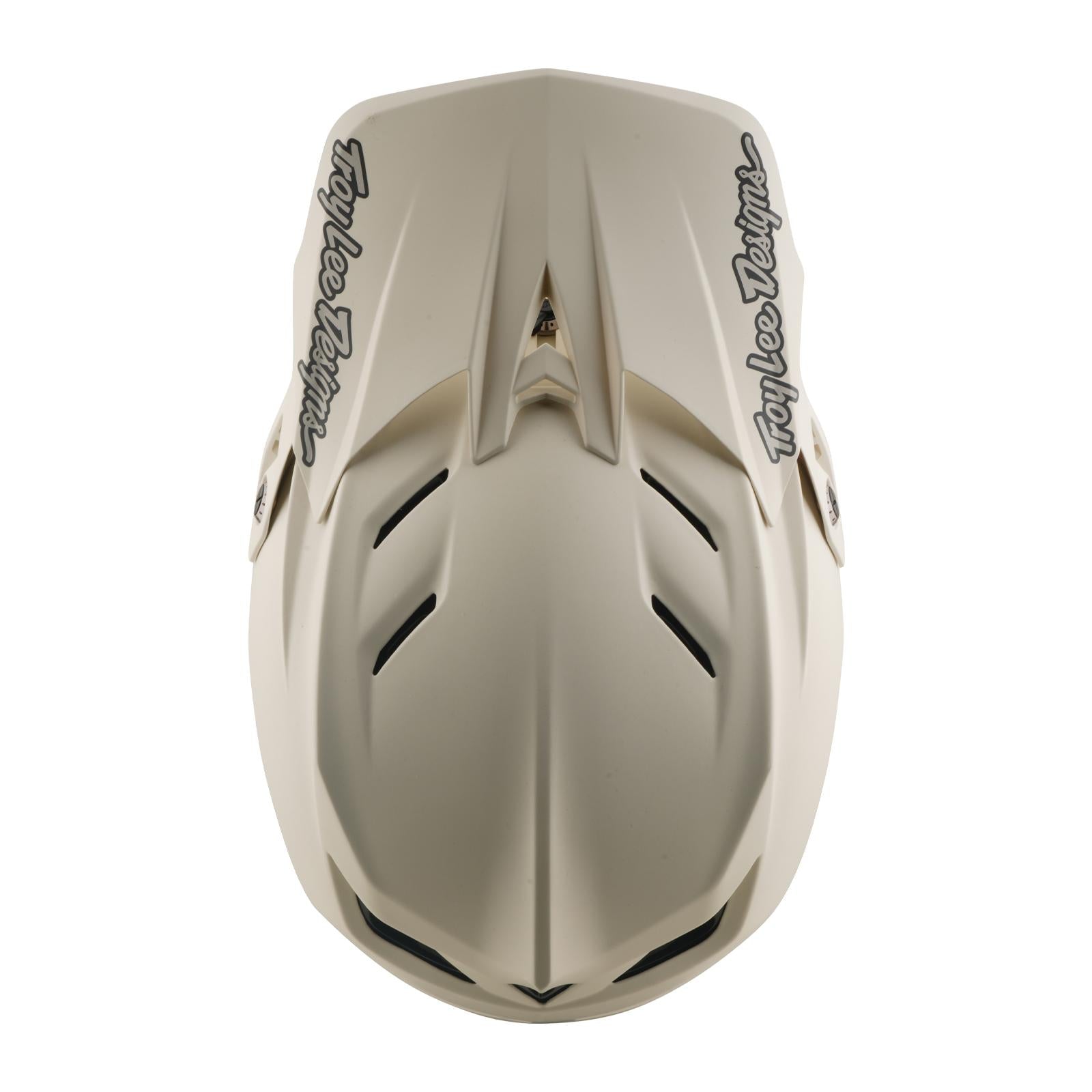 The TLD 26.1 D4 AS Composite Helmet in Stealth Pumice is a beige full-face downhill helmet with black Troy Lee Designs logos, multiple air vents, and Mips protection, shown from above.