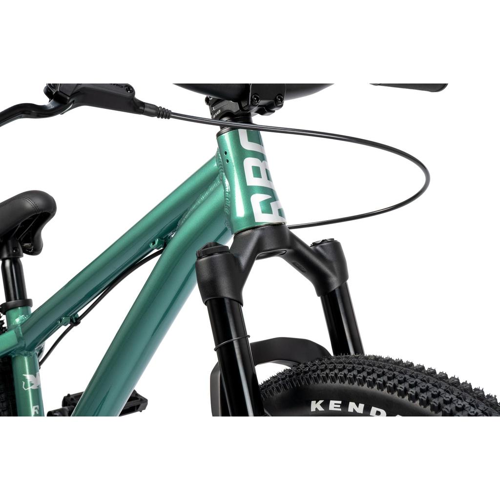 Close-up of the Radio Griffin 24 Inch Dirt Jumper Bike’s front suspension fork, handlebar, tire, frame, and brake cable against a white background.