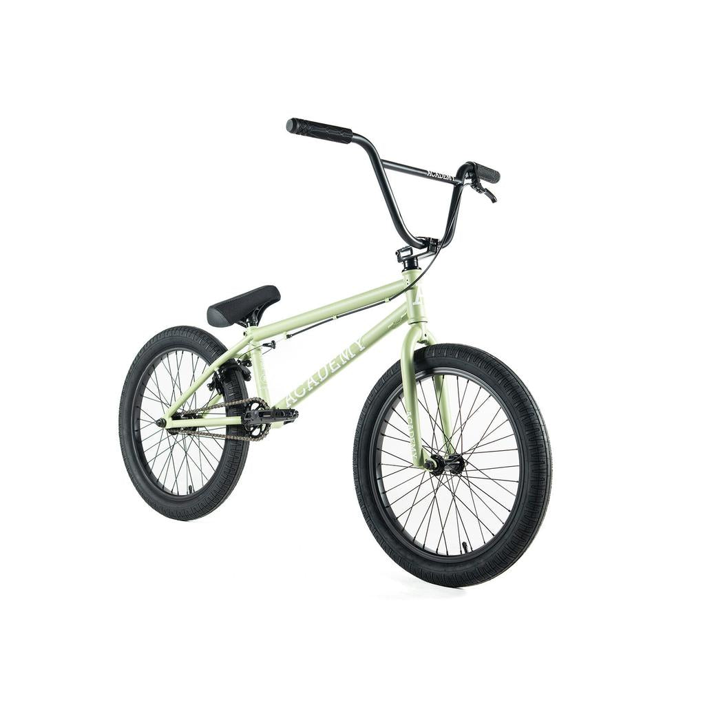 The Academy Aspire 20 Inch Bike is a light green freestyle BMX featuring black CrMo bars, seat, and tires, displayed against a white background.