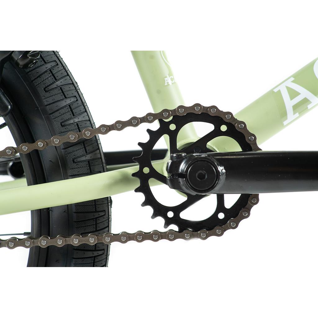 Close-up of the Academy Aspire 20 Inch Bike’s drivetrain, featuring the chain, chainring, crank arm, and rear wheel tire with sealed hubs, set against a white background.