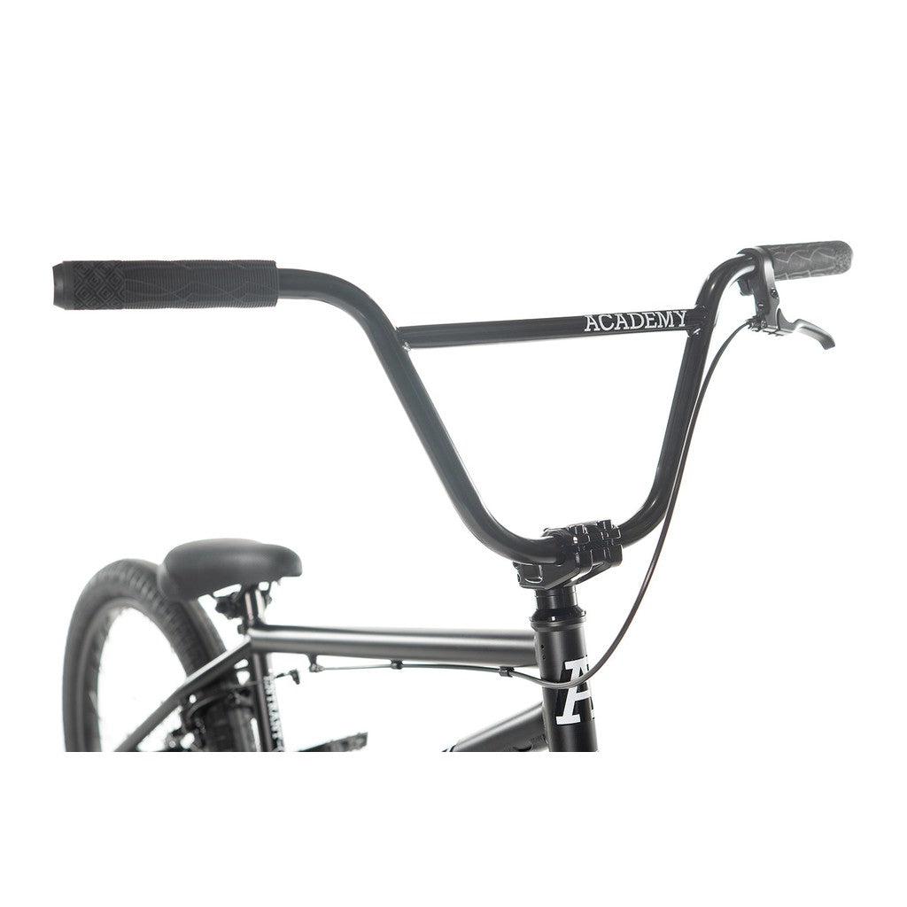 Close-up of the handlebars and part of the frame of an entry-level BMX bike labeled "Academy Entrant 20 Inch Bike" against a white background.