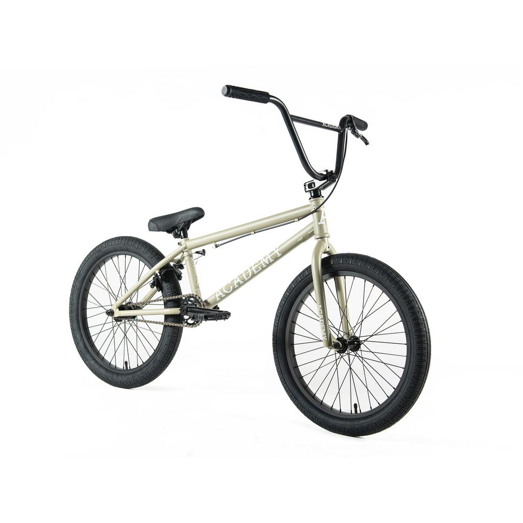 Beige Academy Entrant 20 Inch BMX bike with black handlebars, seat, and tires on a white background. "ACADEMY" is printed on the frame—perfect for beginners and fans of Academy bikes.