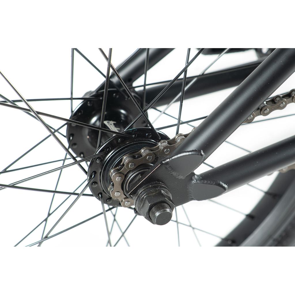 Close-up of the Academy Inspire 18 Bike's rear wheel, highlighting the chain, spokes, axle, and frame dropout with durable double wall rims and sealed hubs, photographed against a white background.