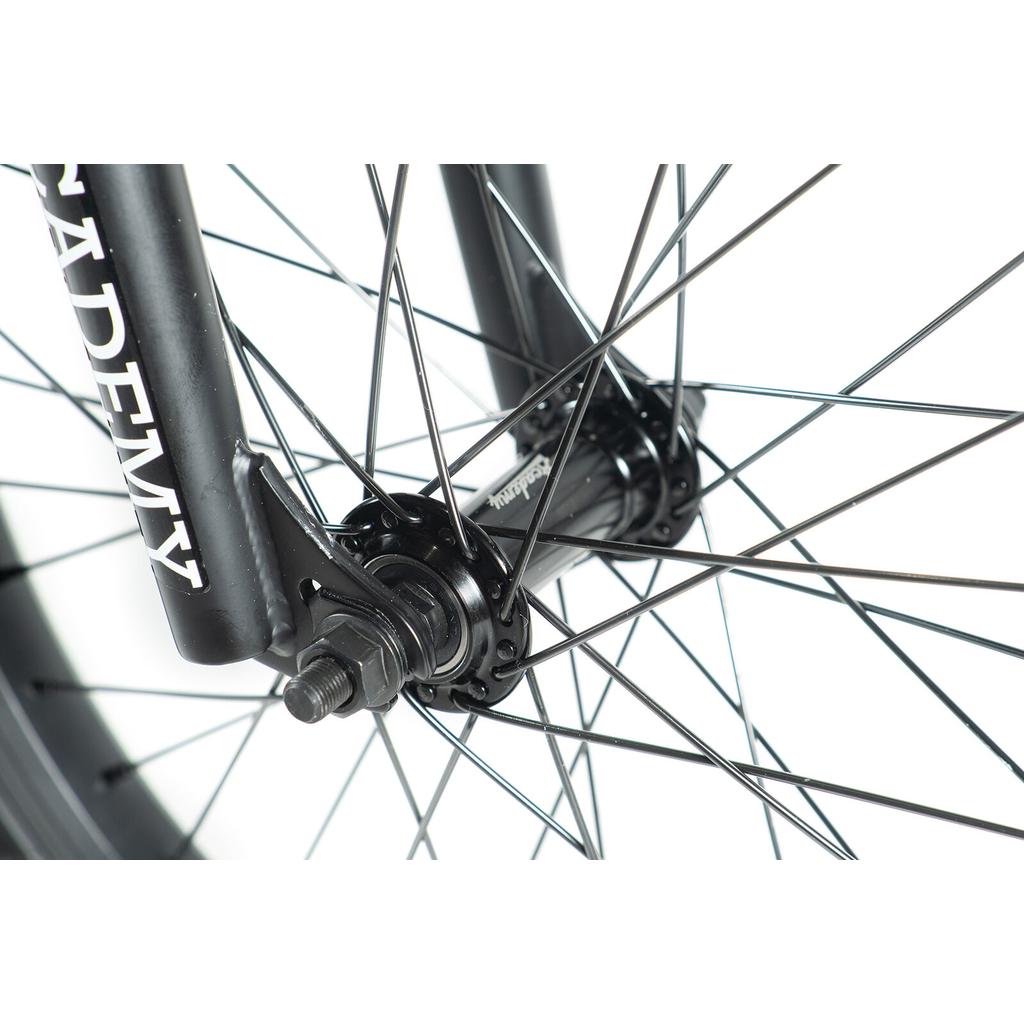 Close-up view of the Academy Inspire 18 Bike's front wheel, showing its 18-inch sealed hub, sturdy spokes, and fork with "ACADEMY" branding.